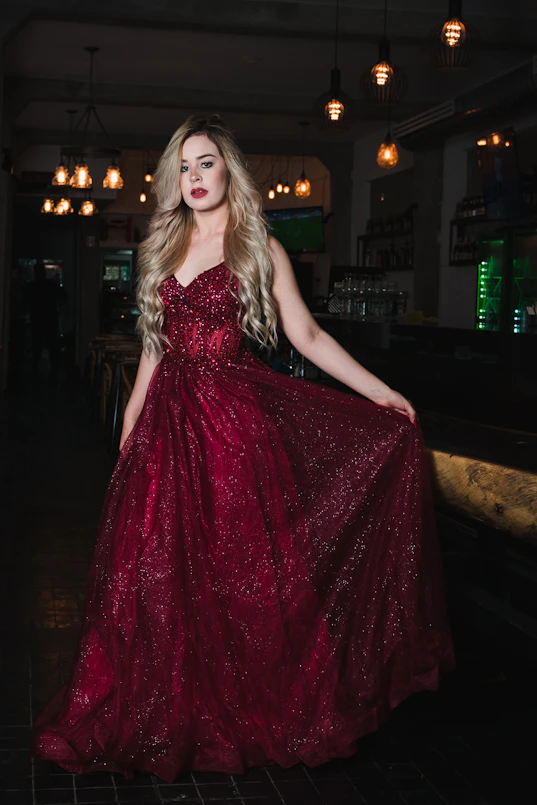 Woman in a sparkling red gown at a bar