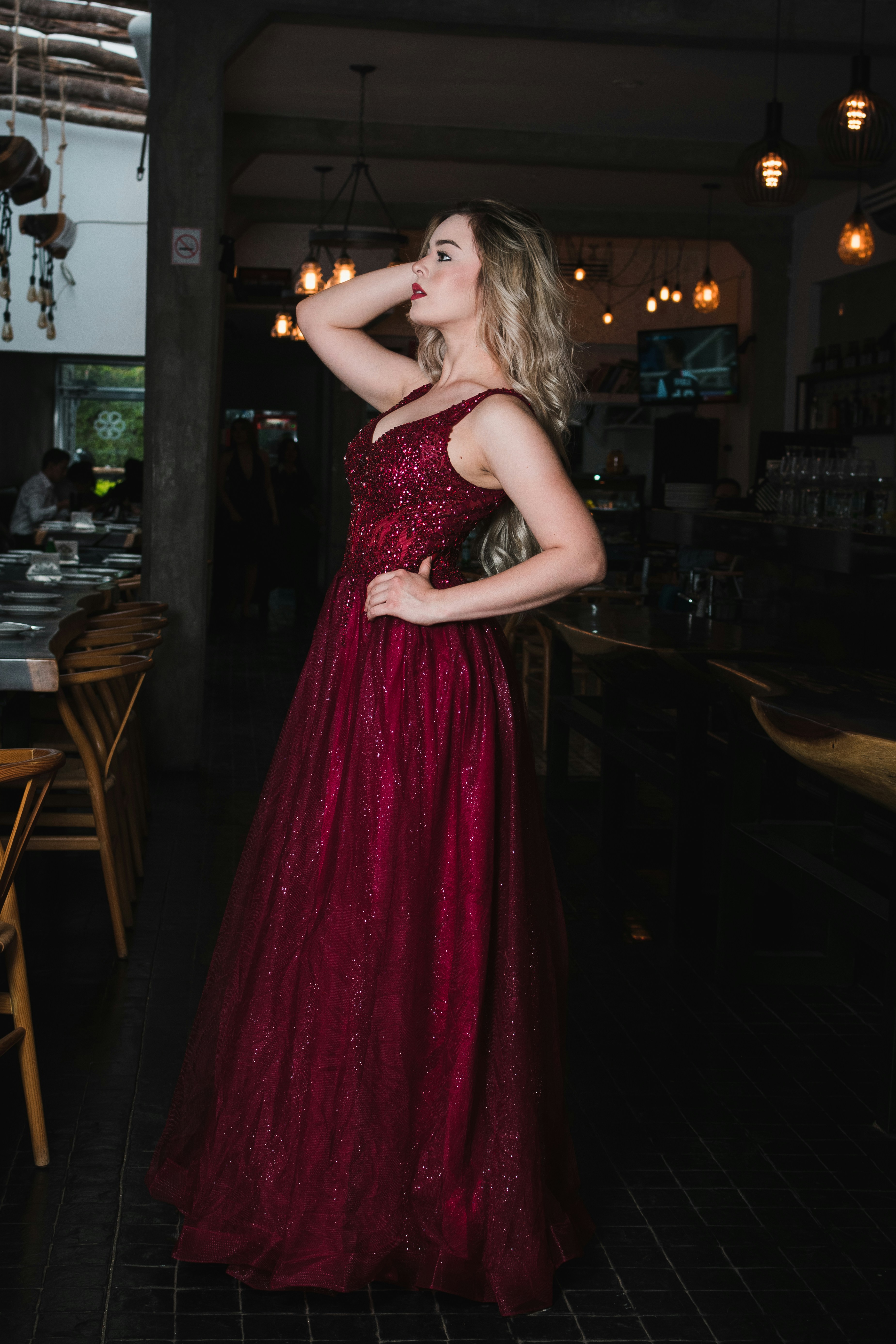 Woman in a sparkling red dress posing indoors.