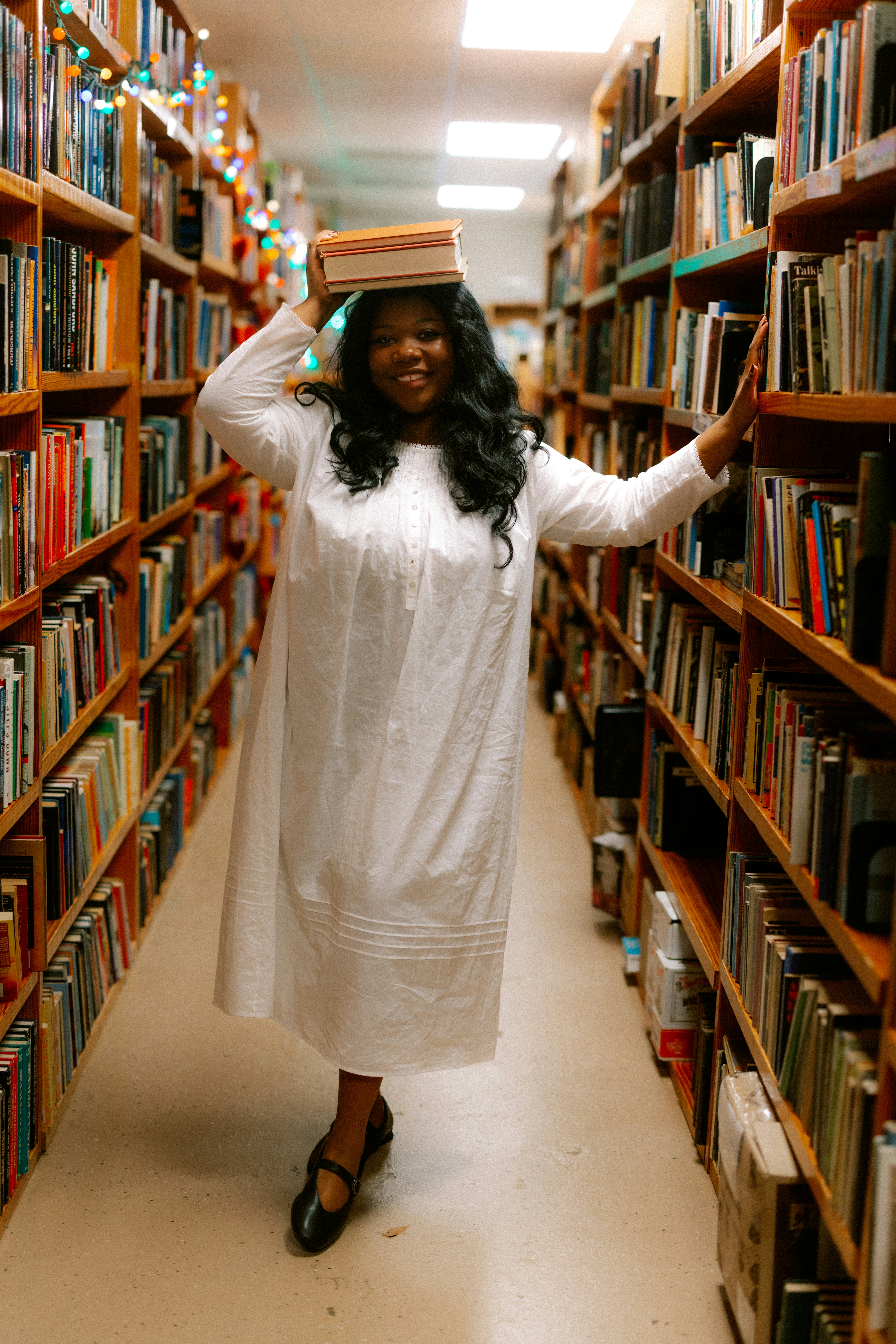 Woman with books on her head in a bookstore