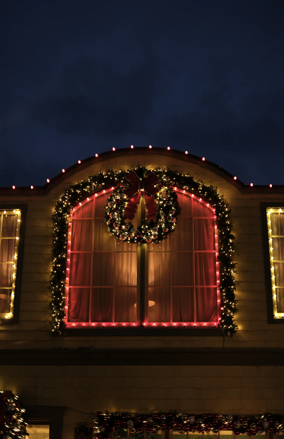 Festive house with elegant outdoor Christmas lights and a wreath