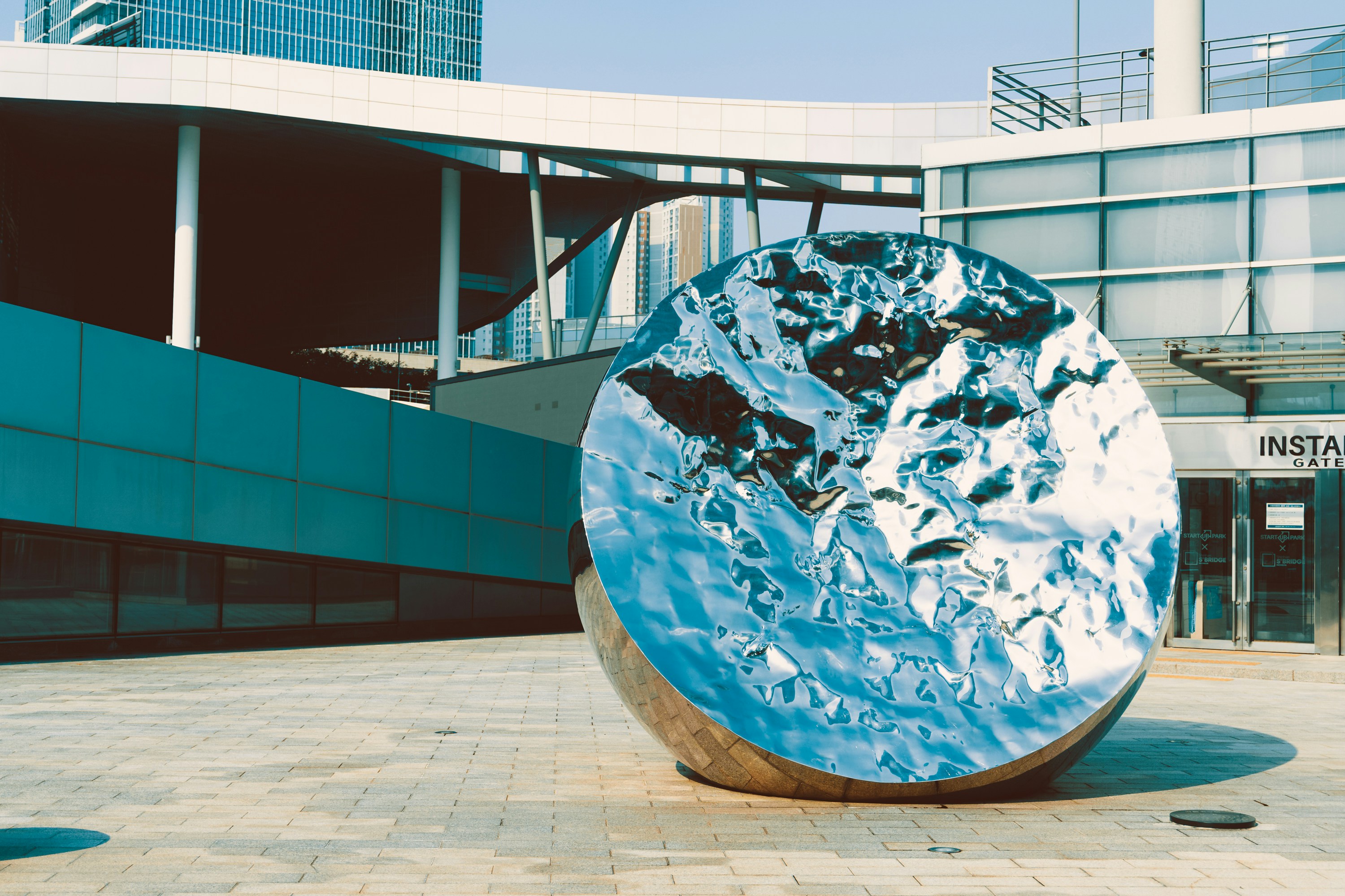 Reflective sphere sculpture in urban plaza