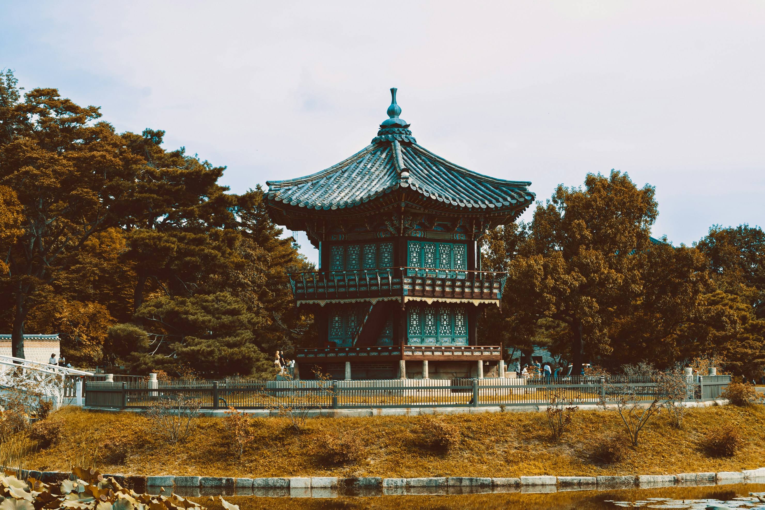Traditional korean pavilion surrounded by trees near water