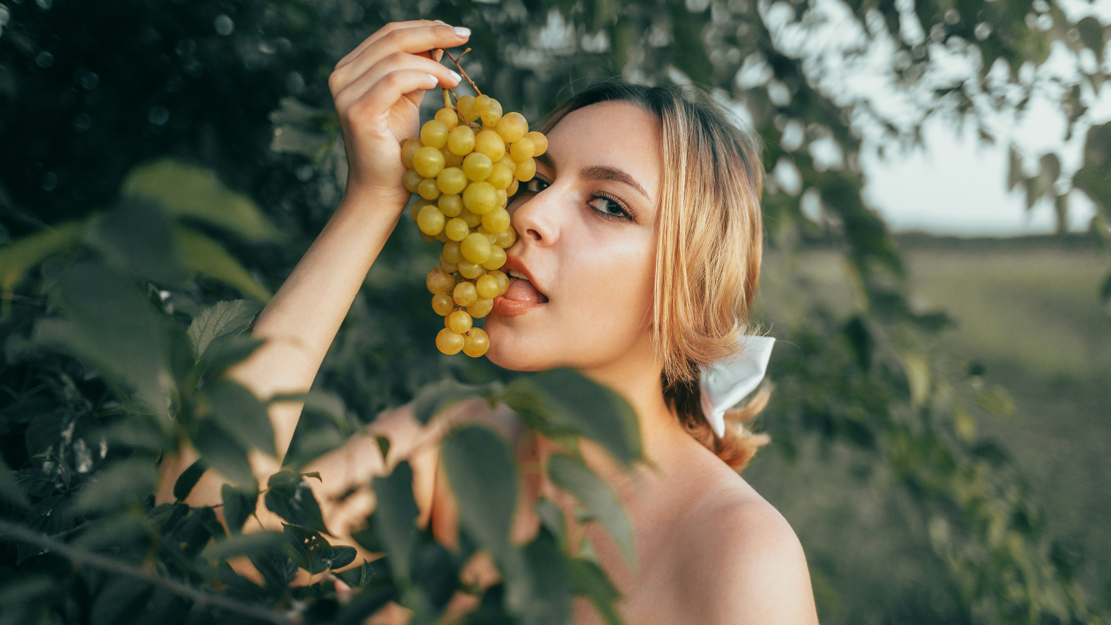 Woman tasting grapes in a garden setting