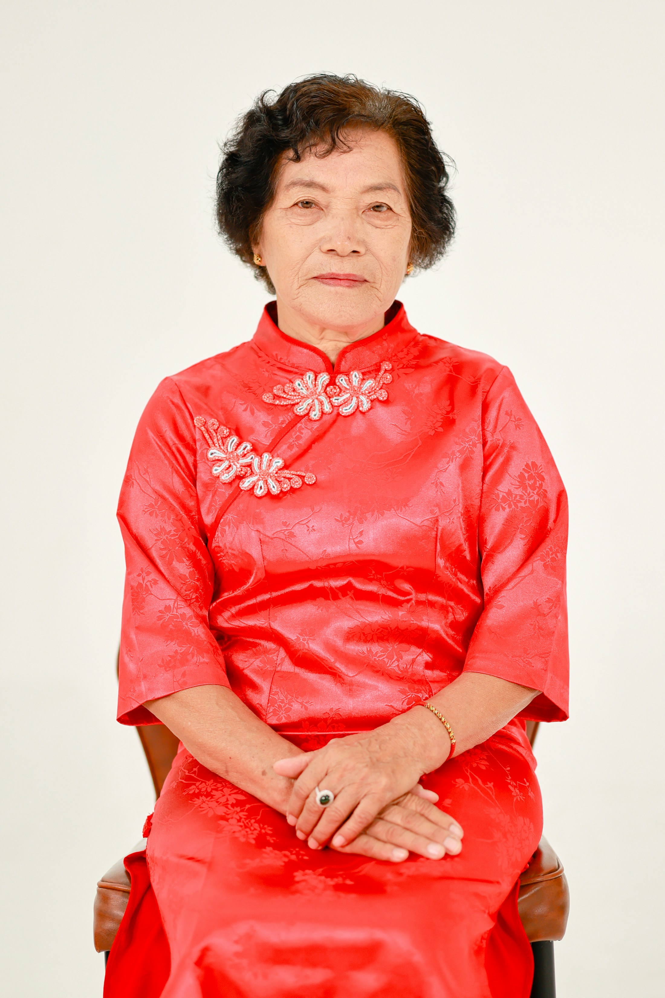 Elderly asian woman in a red traditional dress.