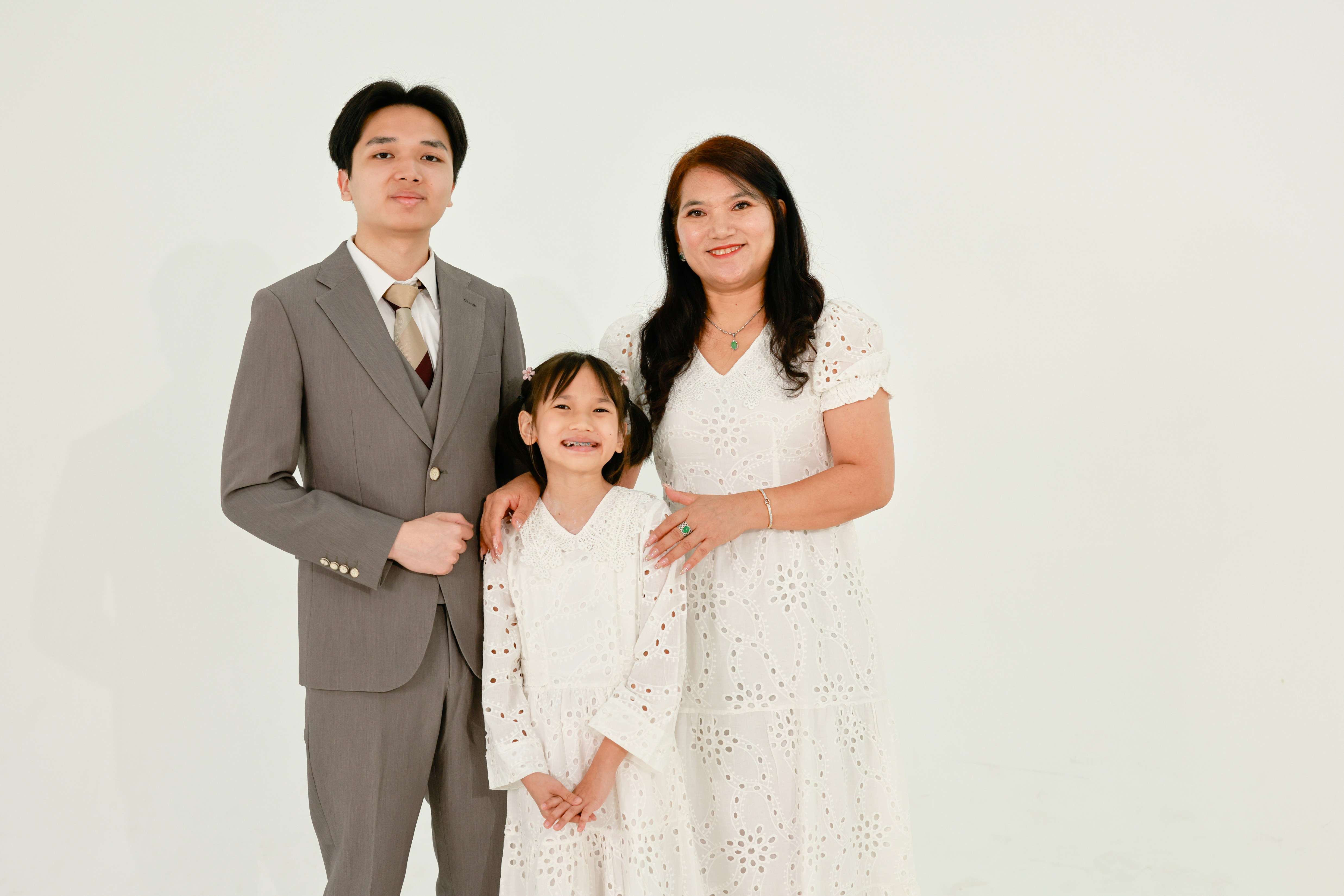 A family of three posing for a studio portrait.