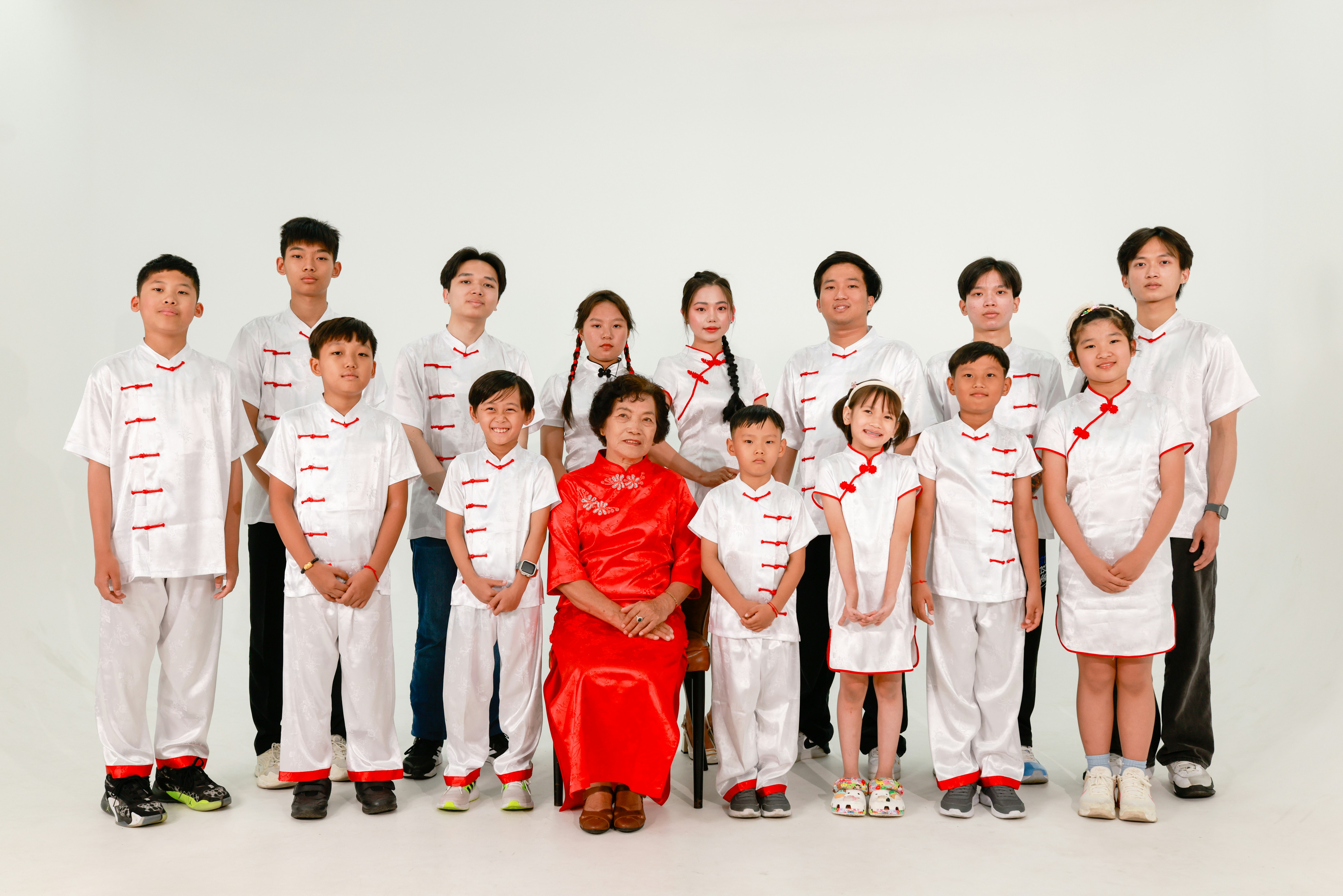 Una famiglia posa con abiti bianchi e rossi abbinati.