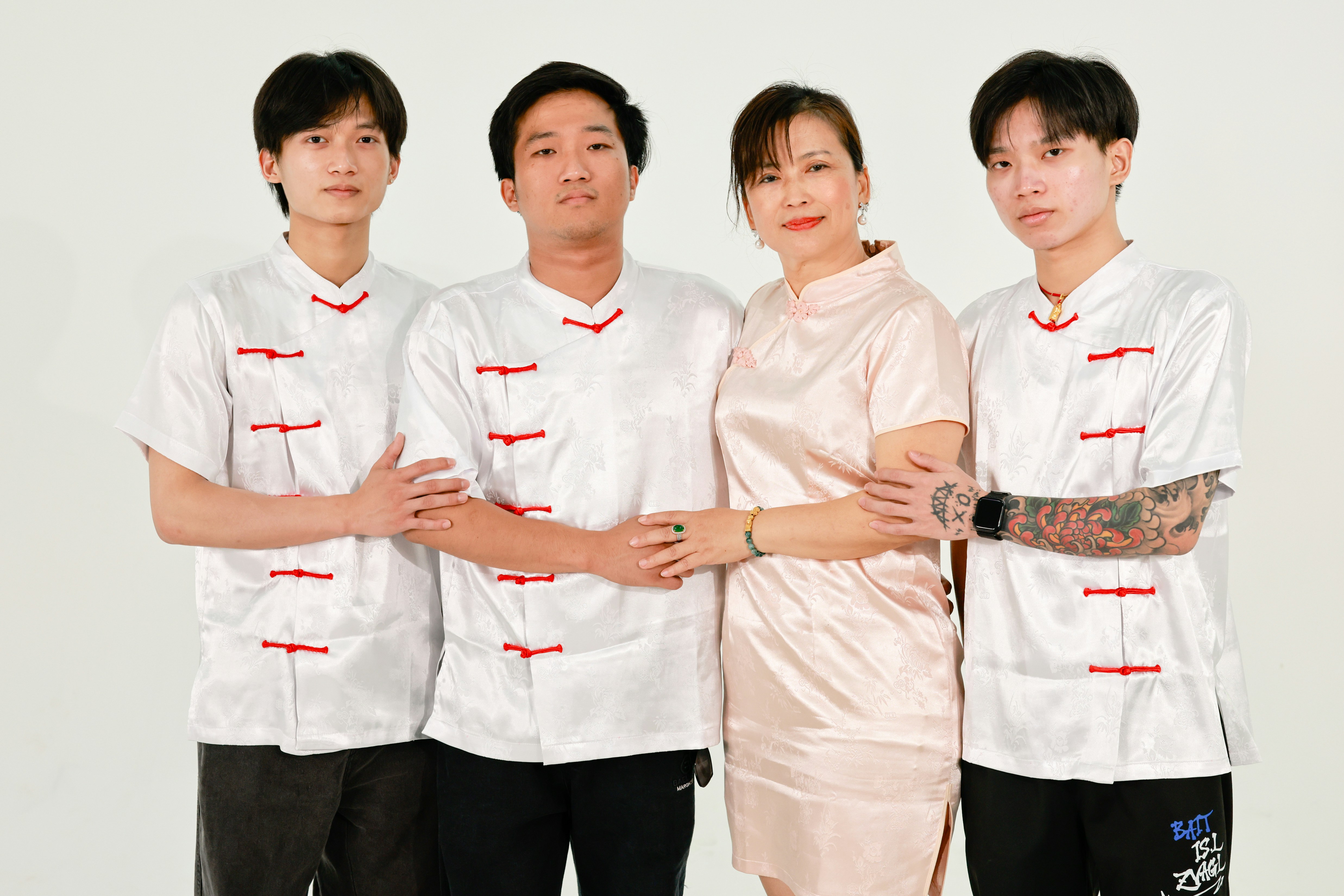 Familie in traditioneller chinesischer Kleidung, die Foral-Outfits posiert