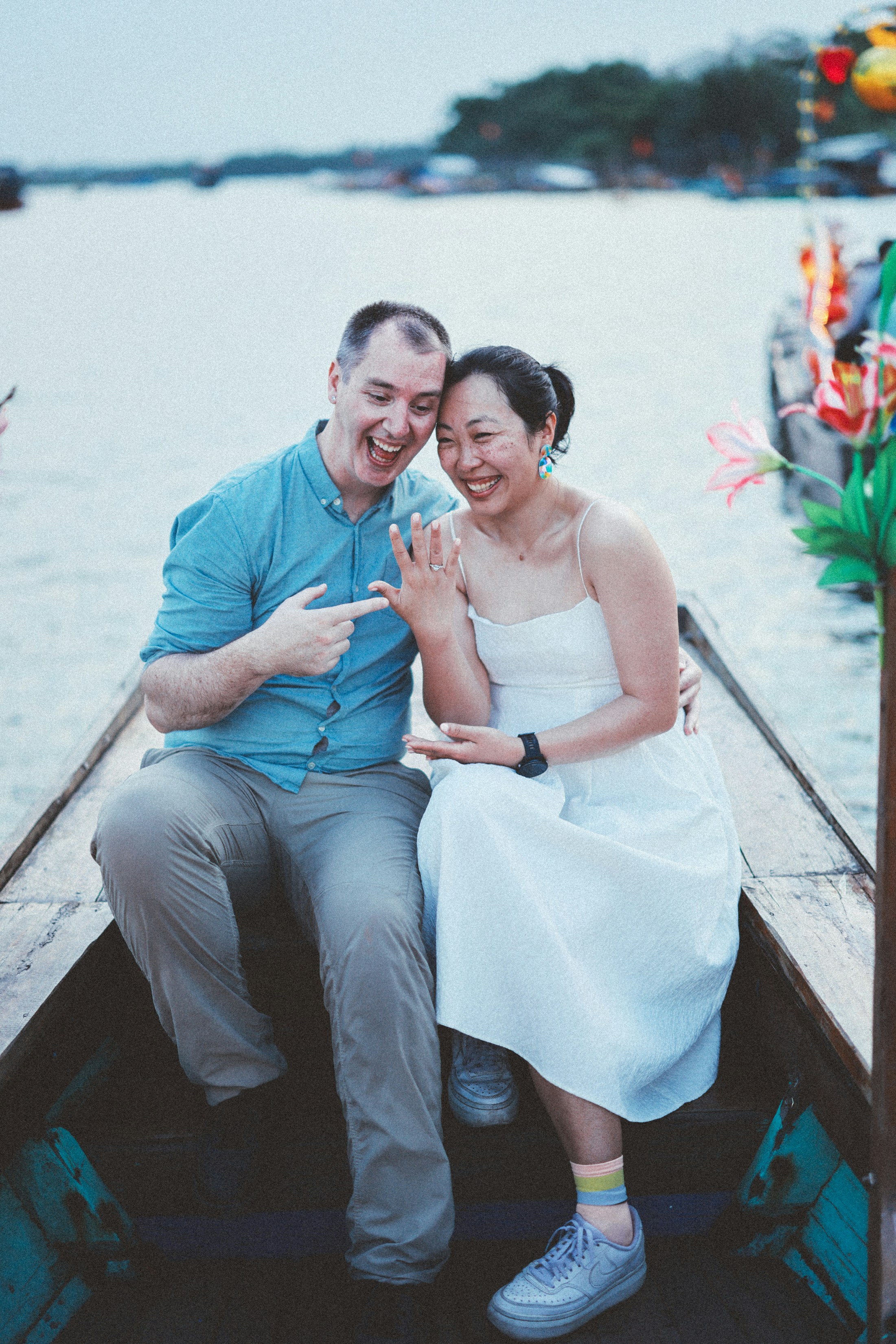 Couple showing engagement ring on a boat