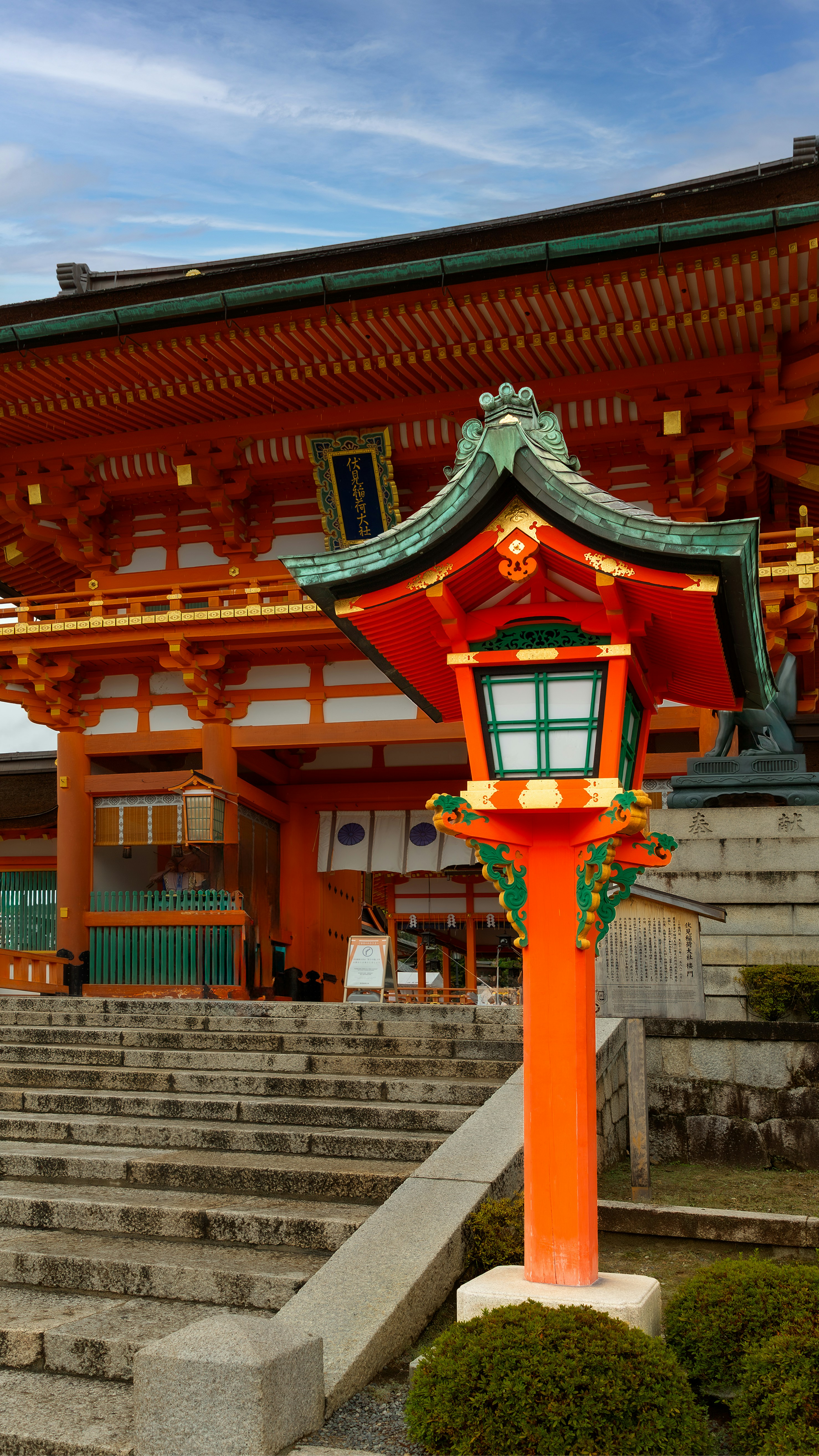 Orange lantern in front of a japanese temple entrance.