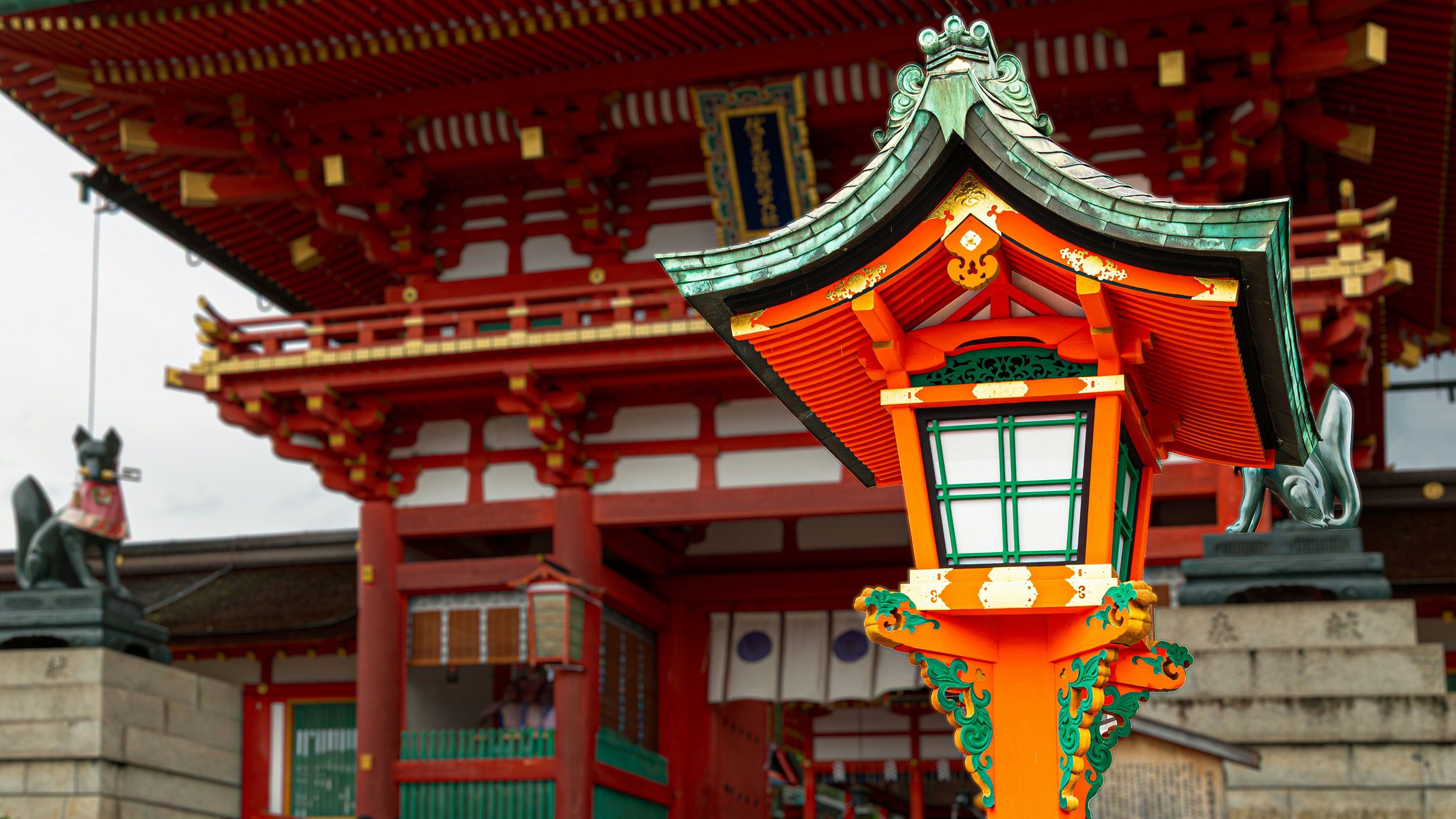 Traditional japanese temple with ornate lantern and fox statues