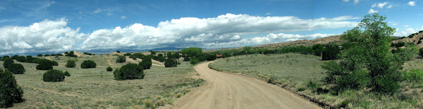 Dusty dirt road winding through the dry Southwest landscape — J.P. Barelli author site banner