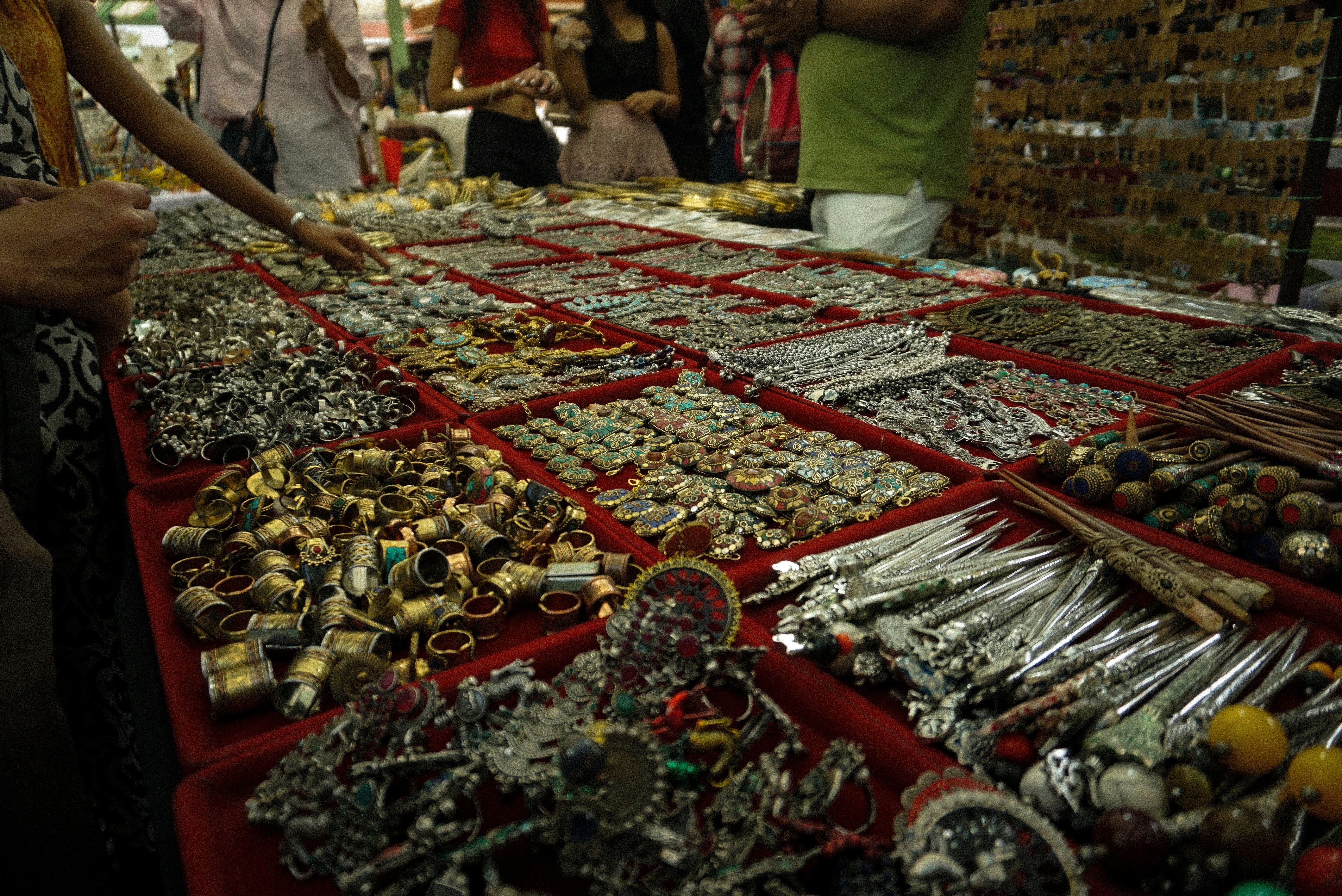 A bustling Indian market street with a prominent, well-lit jewelry shop displaying gold ornaments, capturing the local economic activity.