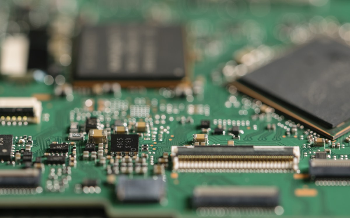 Close-up of a green circuit board with microchips representing semiconductor manufacturing technology