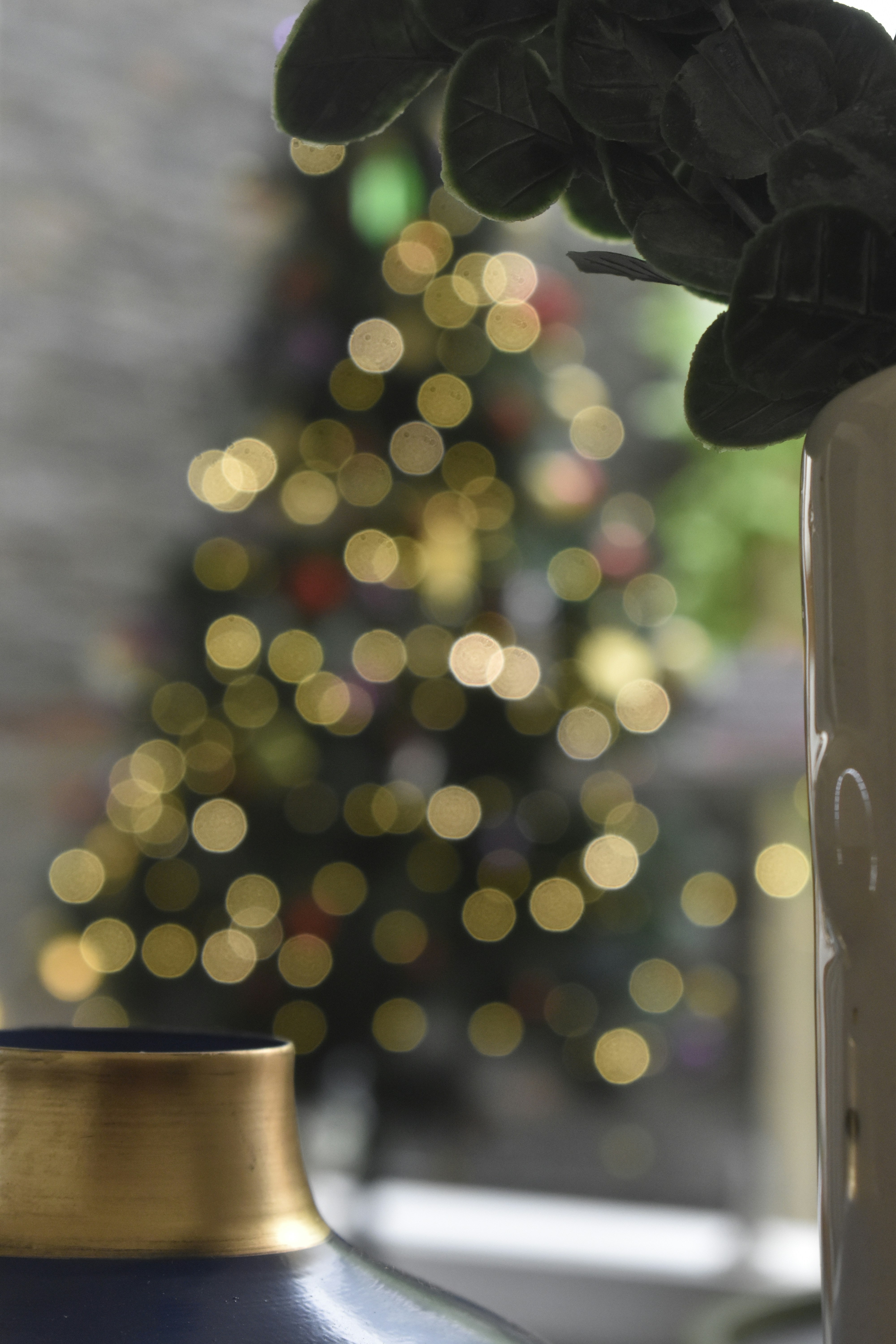 Blurred christmas tree with festive lights and vases.