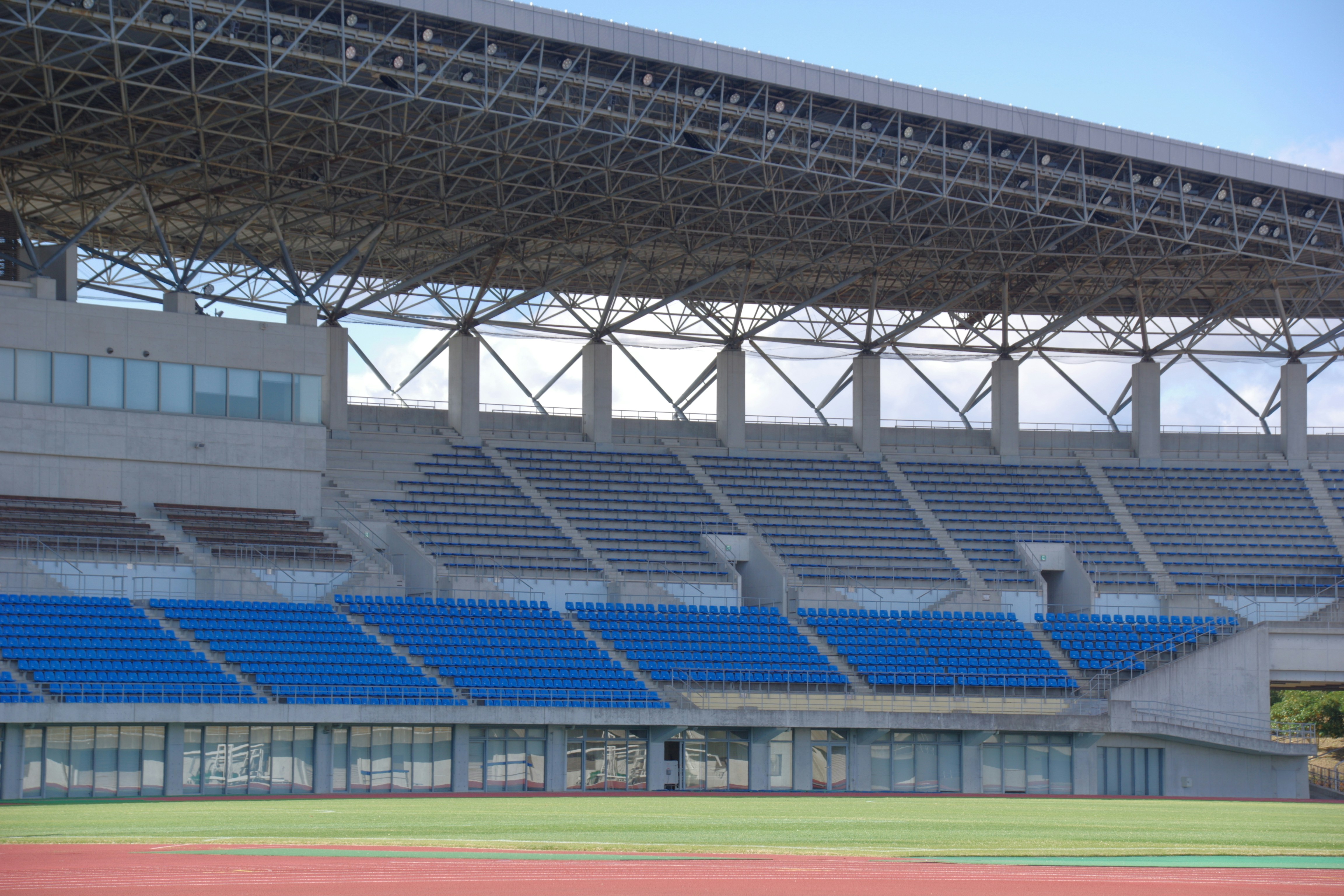 Empty stadium seats under a large metal roof