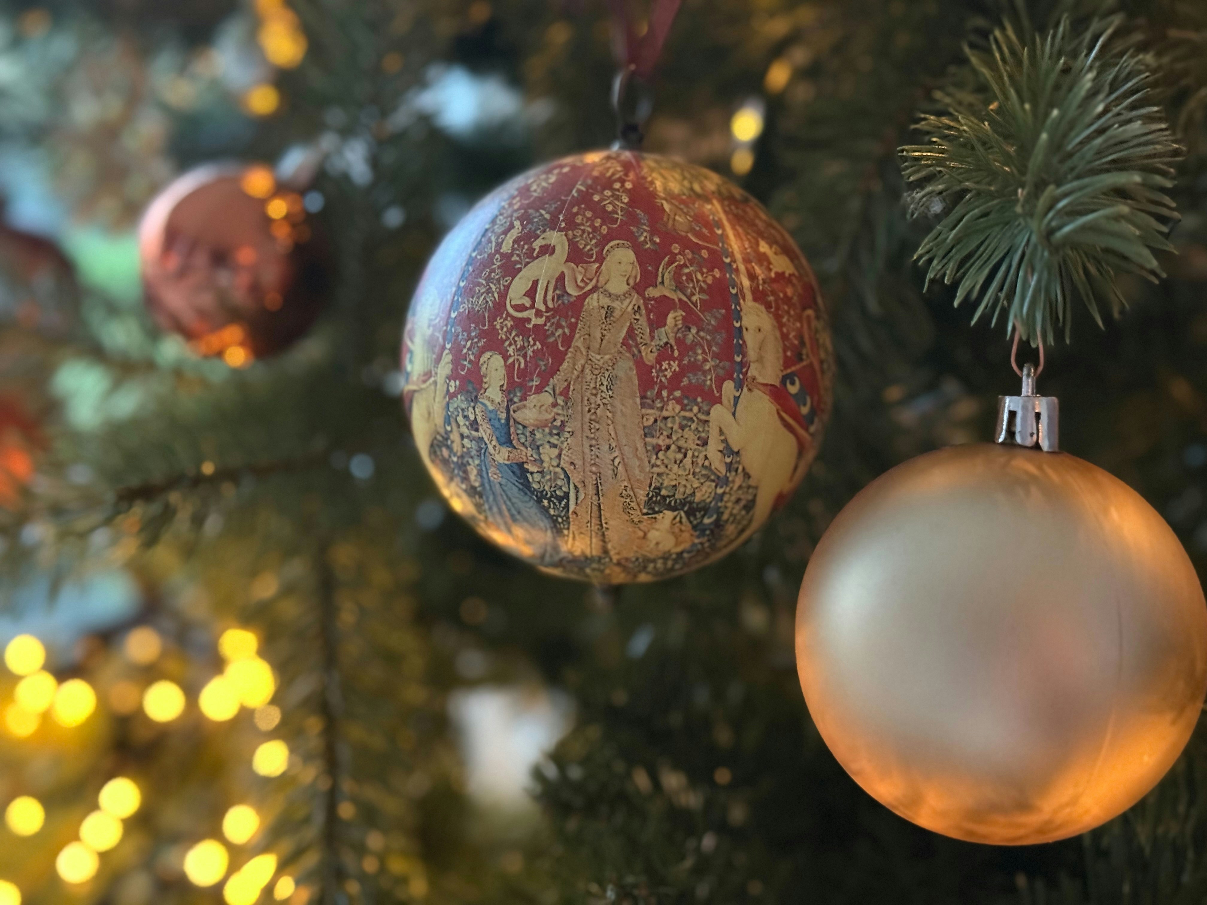Christmas ornaments hanging on a decorated tree.