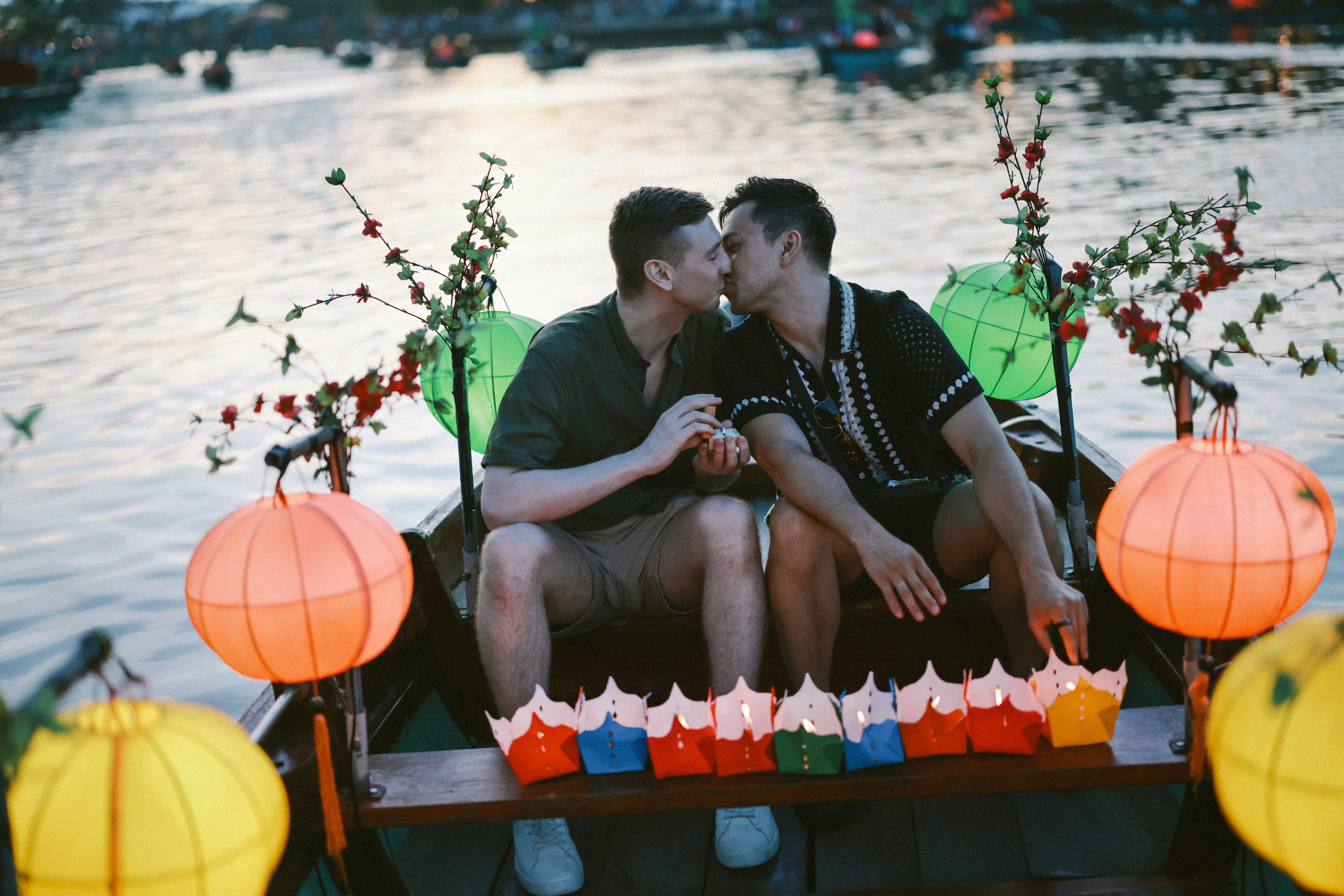Couple kissing in a boat with lanterns