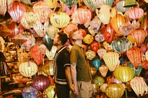 Two men looking up at colorful hanging lanterns