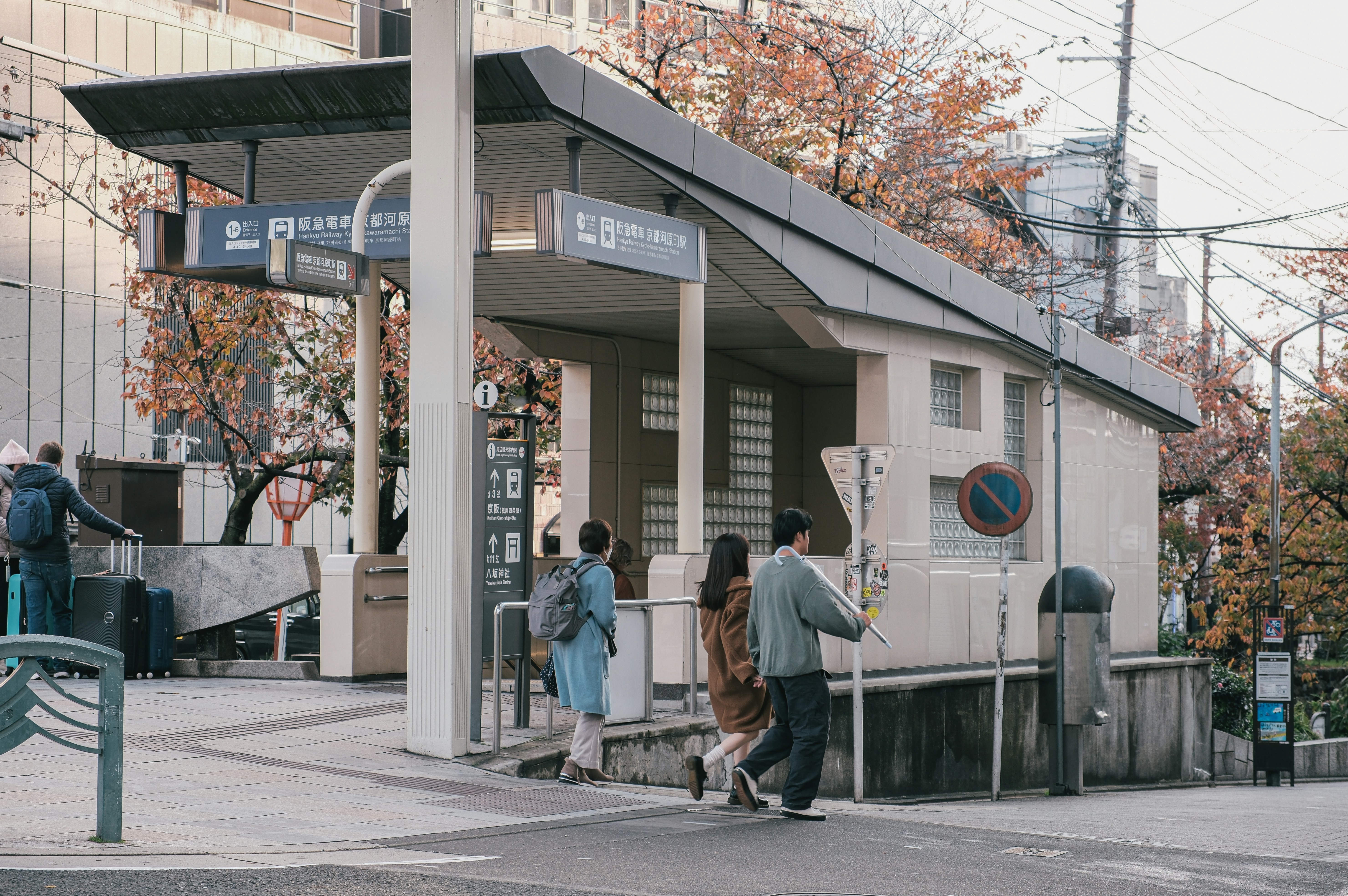 People entering a modern building entrance in autumn.