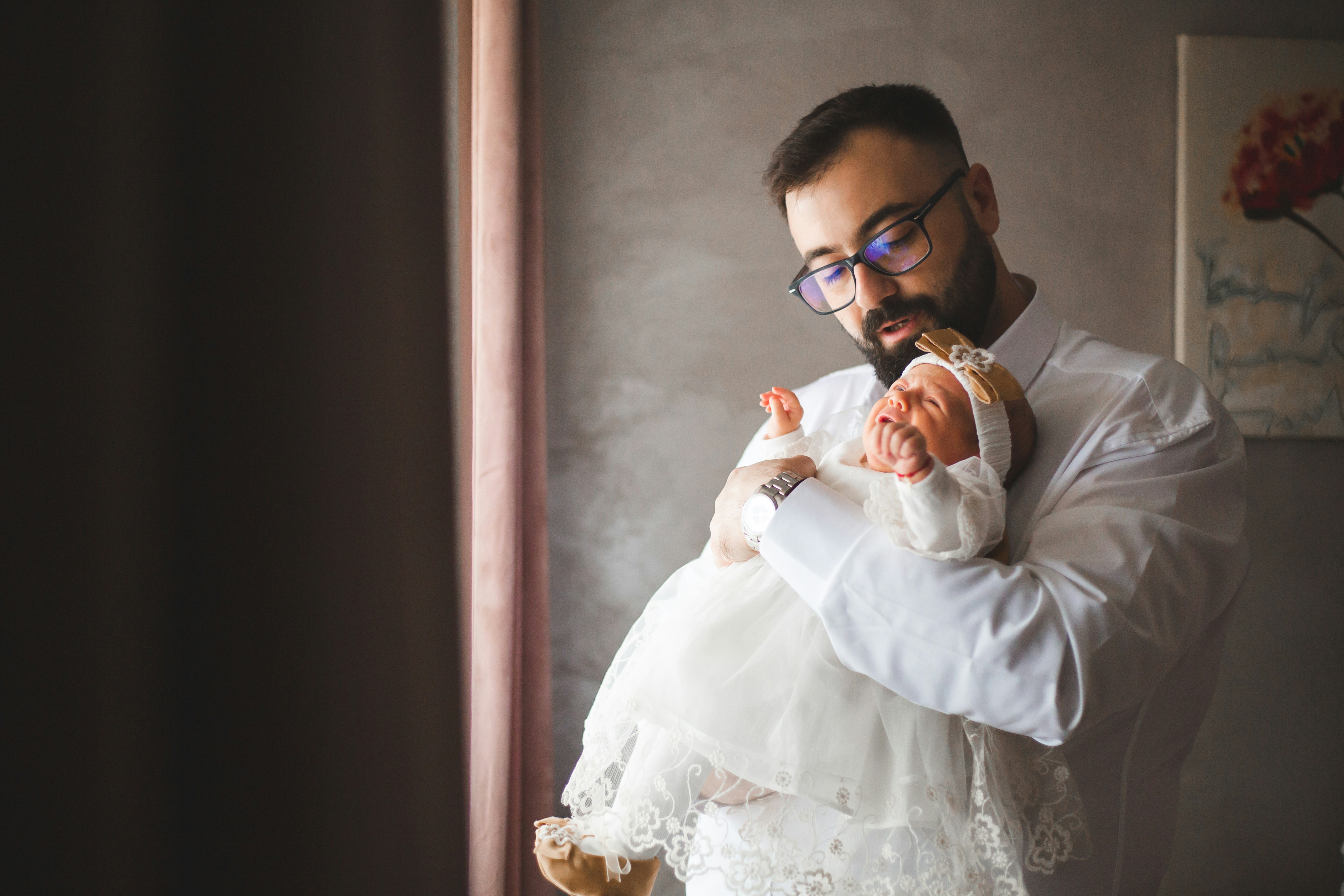 Father holding his newborn baby daughter gently