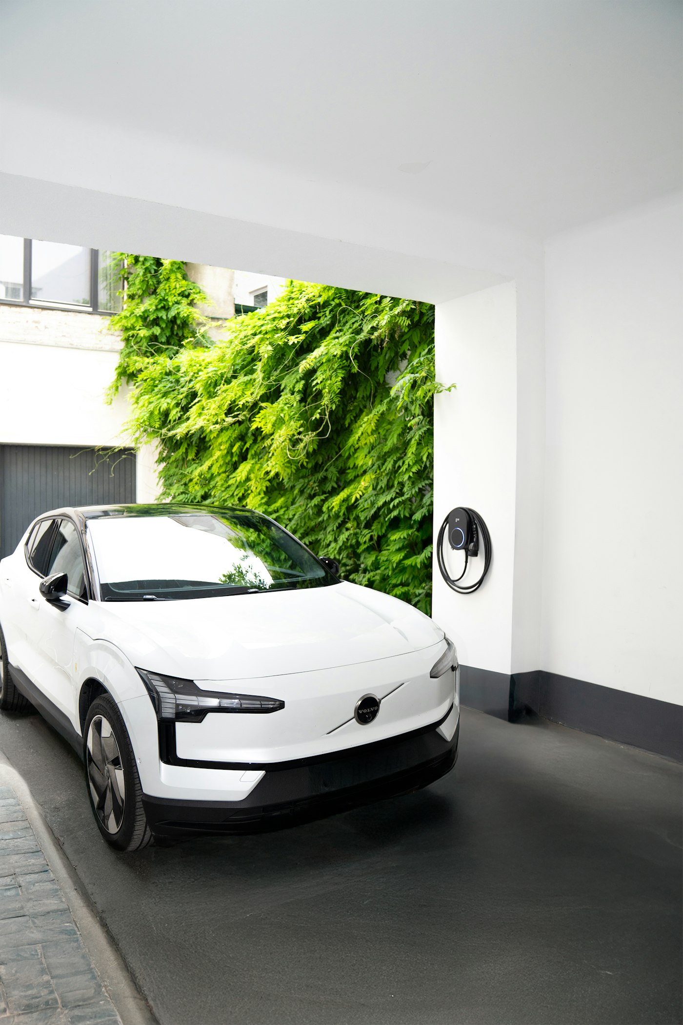 Witte elektrische auto bij een thuislader