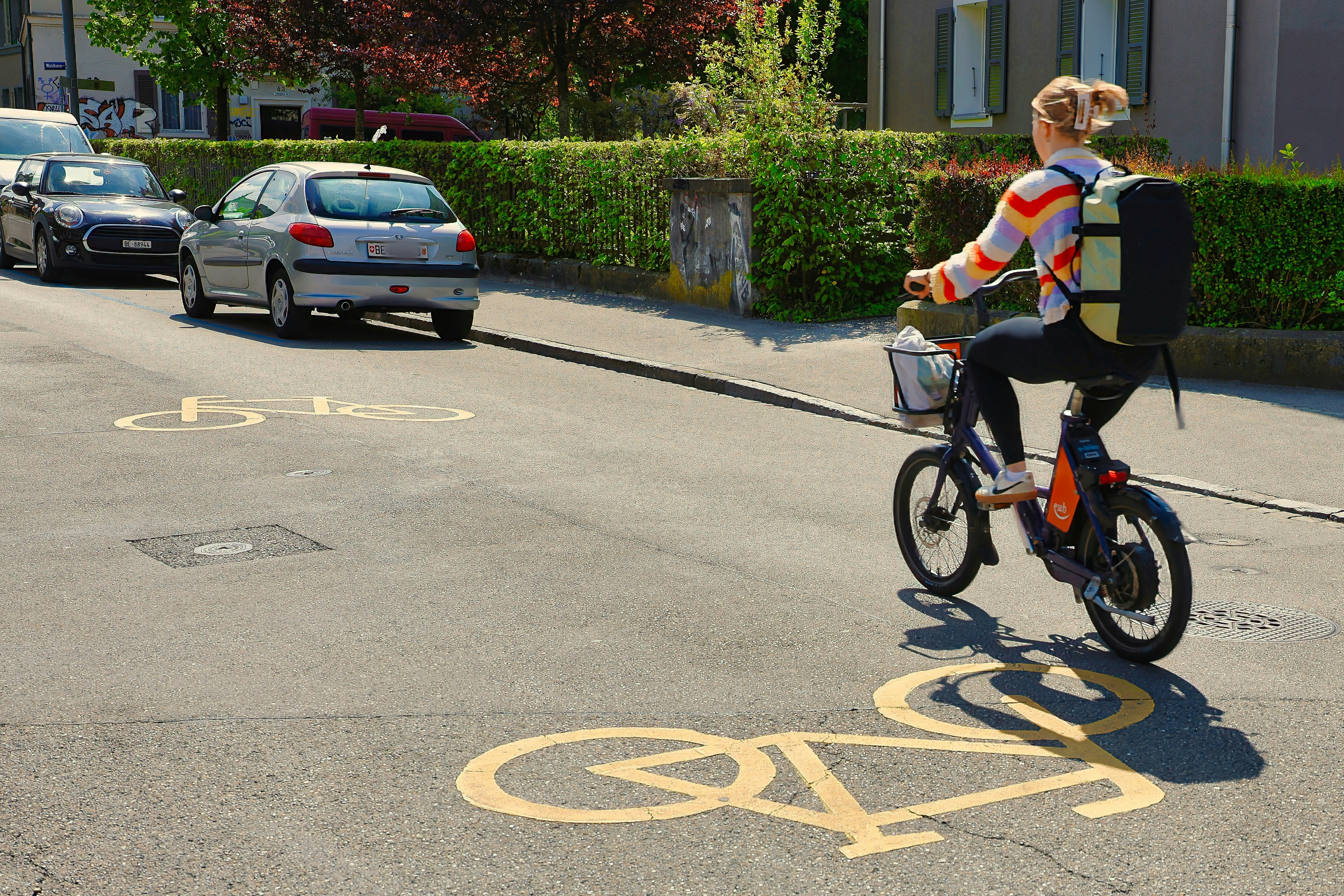 Woman riding electric bike on street with bike lane markings