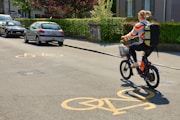 Woman riding electric bike on street with bike lane markings