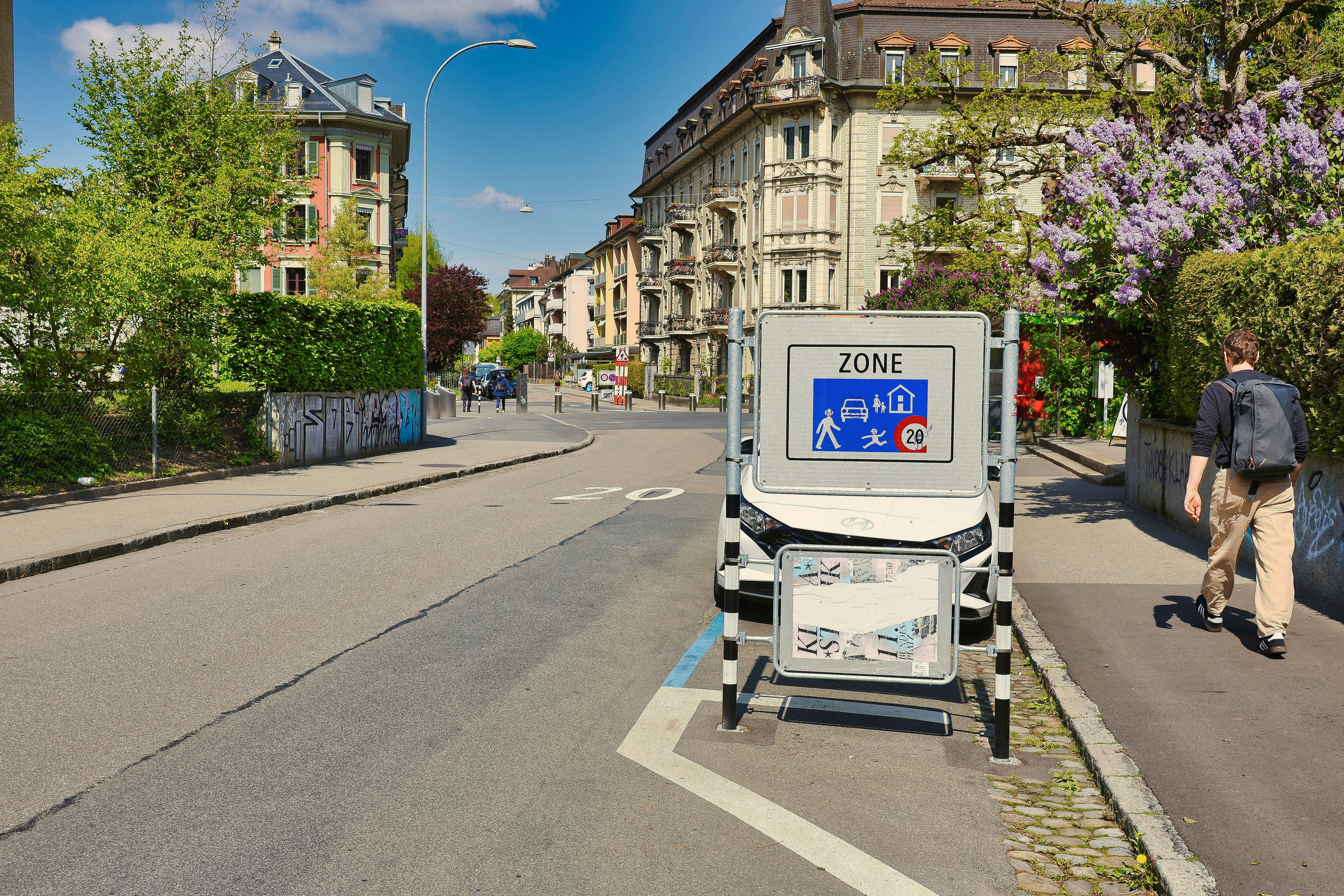 A person walks past a street sign in a city.