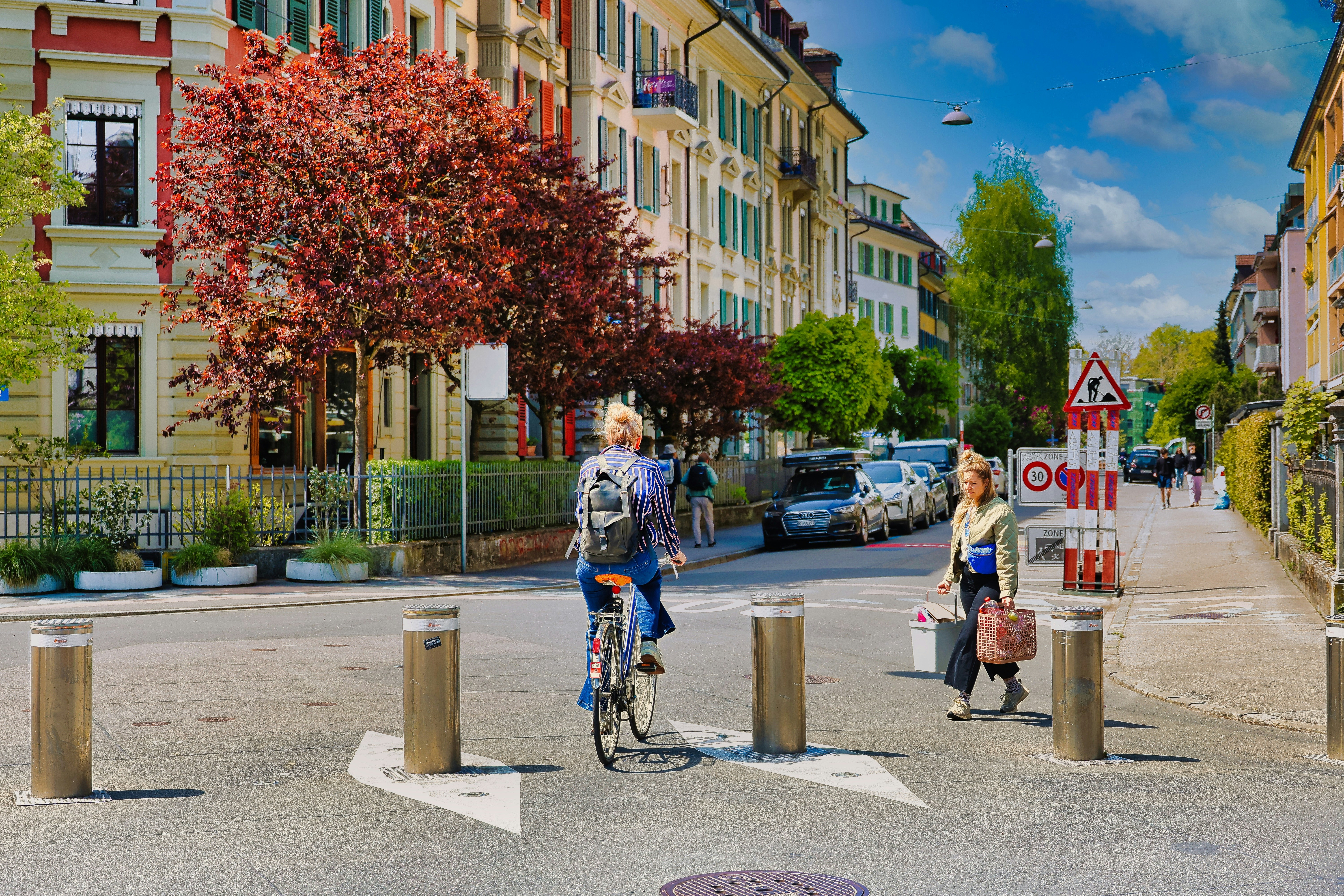 People cycling and walking on a city street.