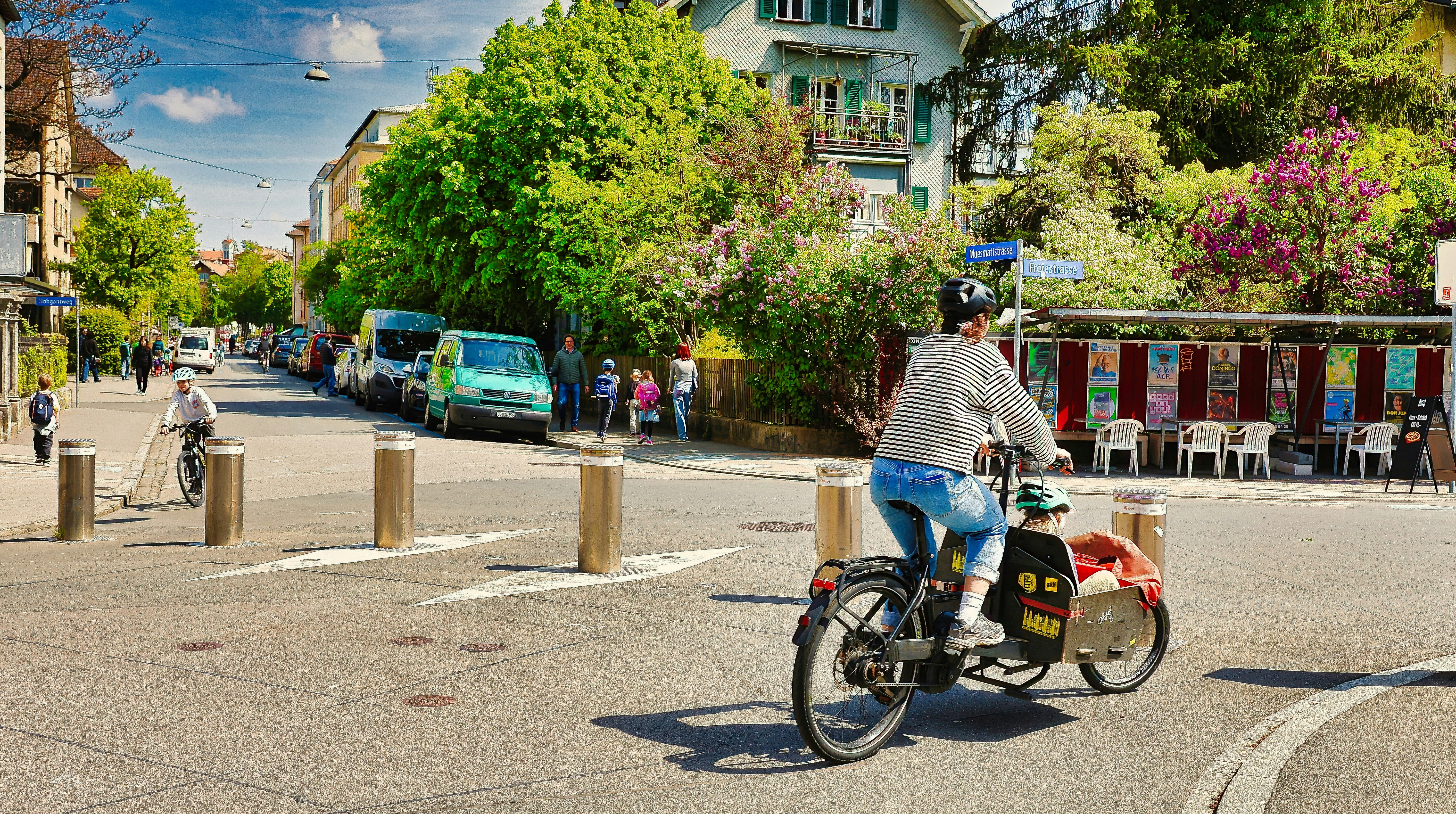 Person rides bicycle with child trailer on street