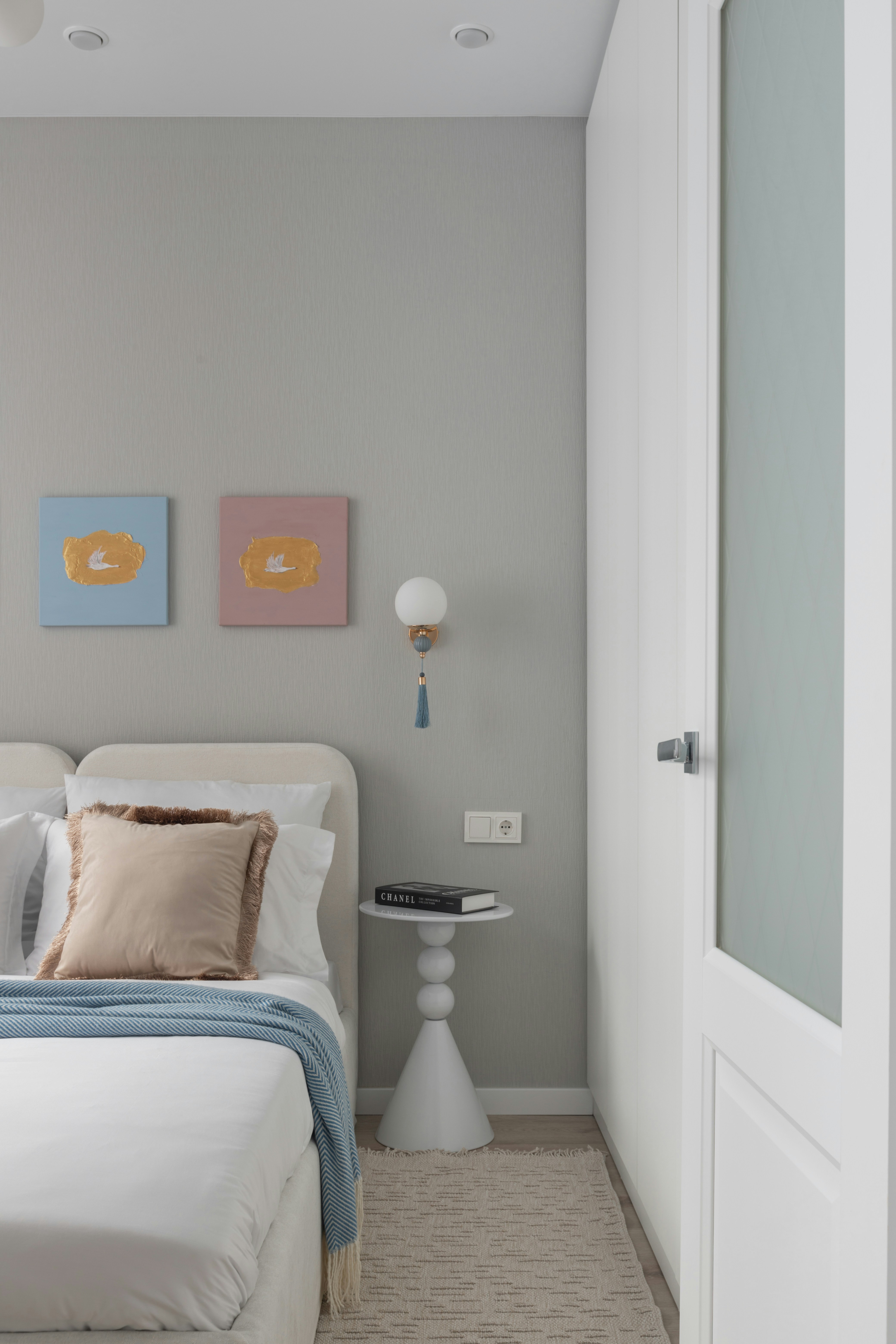 Minimalist bedroom with two abstract paintings.