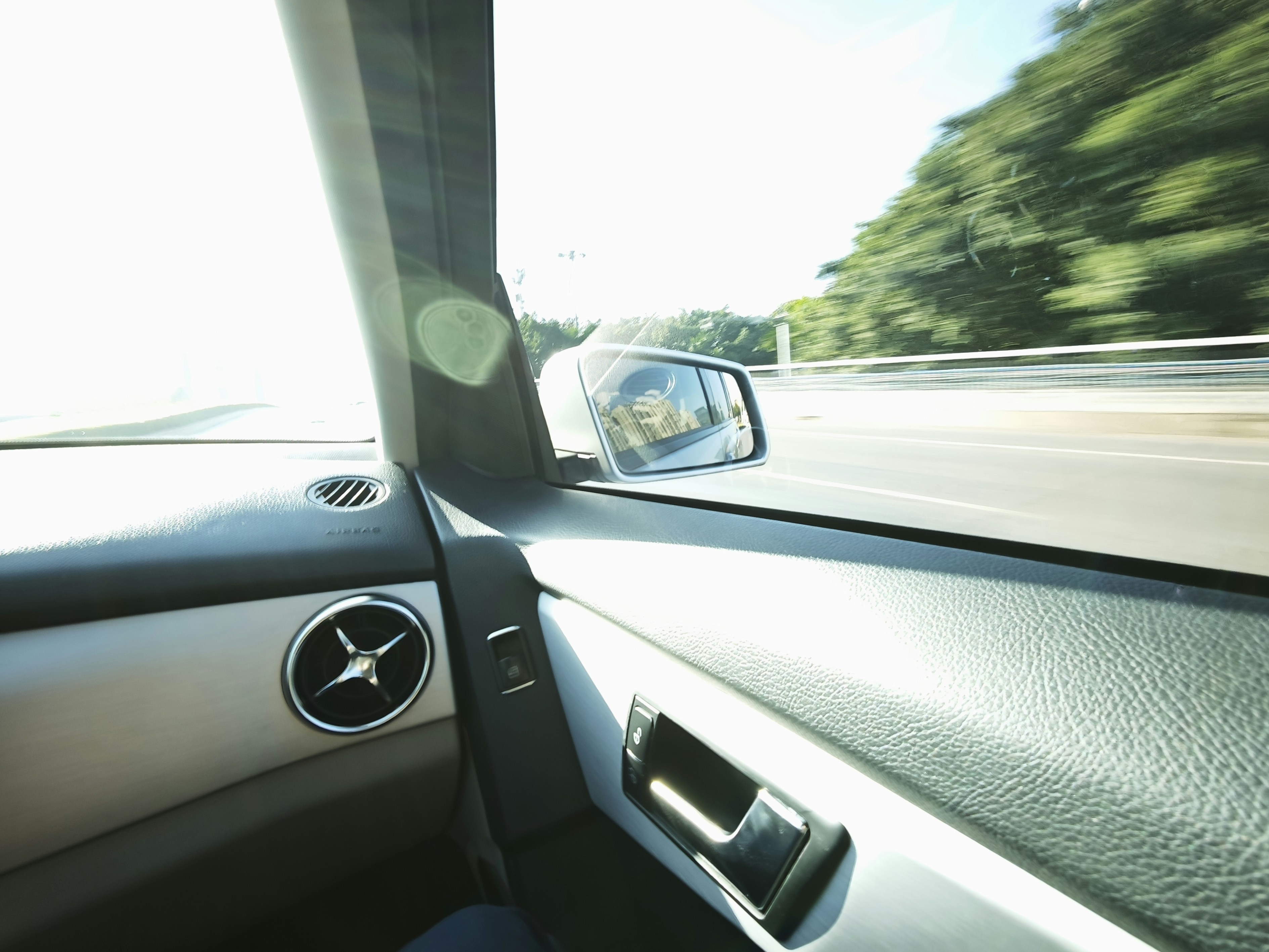 Driving on a sunny day with trees blurring past.