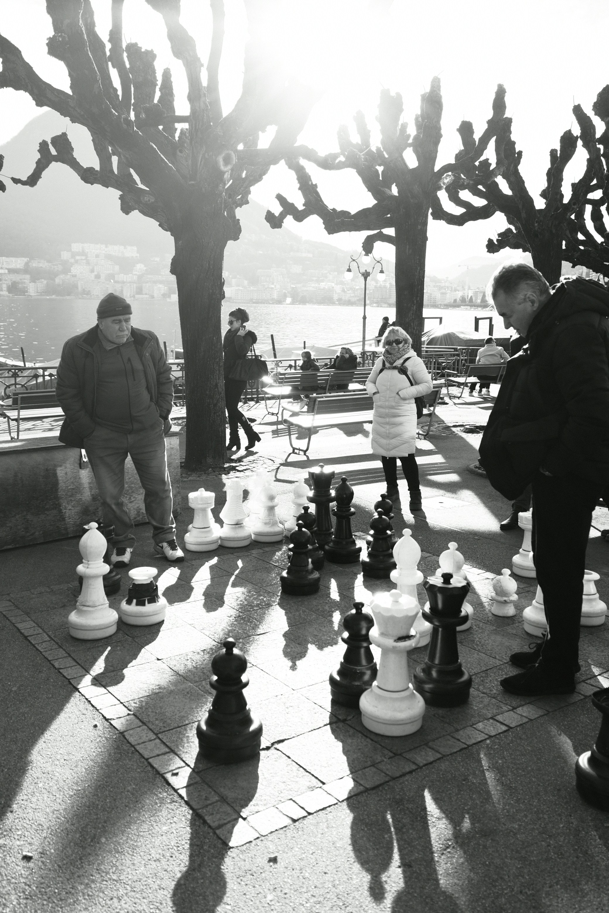 People playing giant chess outdoors on a sunny day.