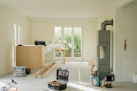 Room under renovation with tools and furniture.