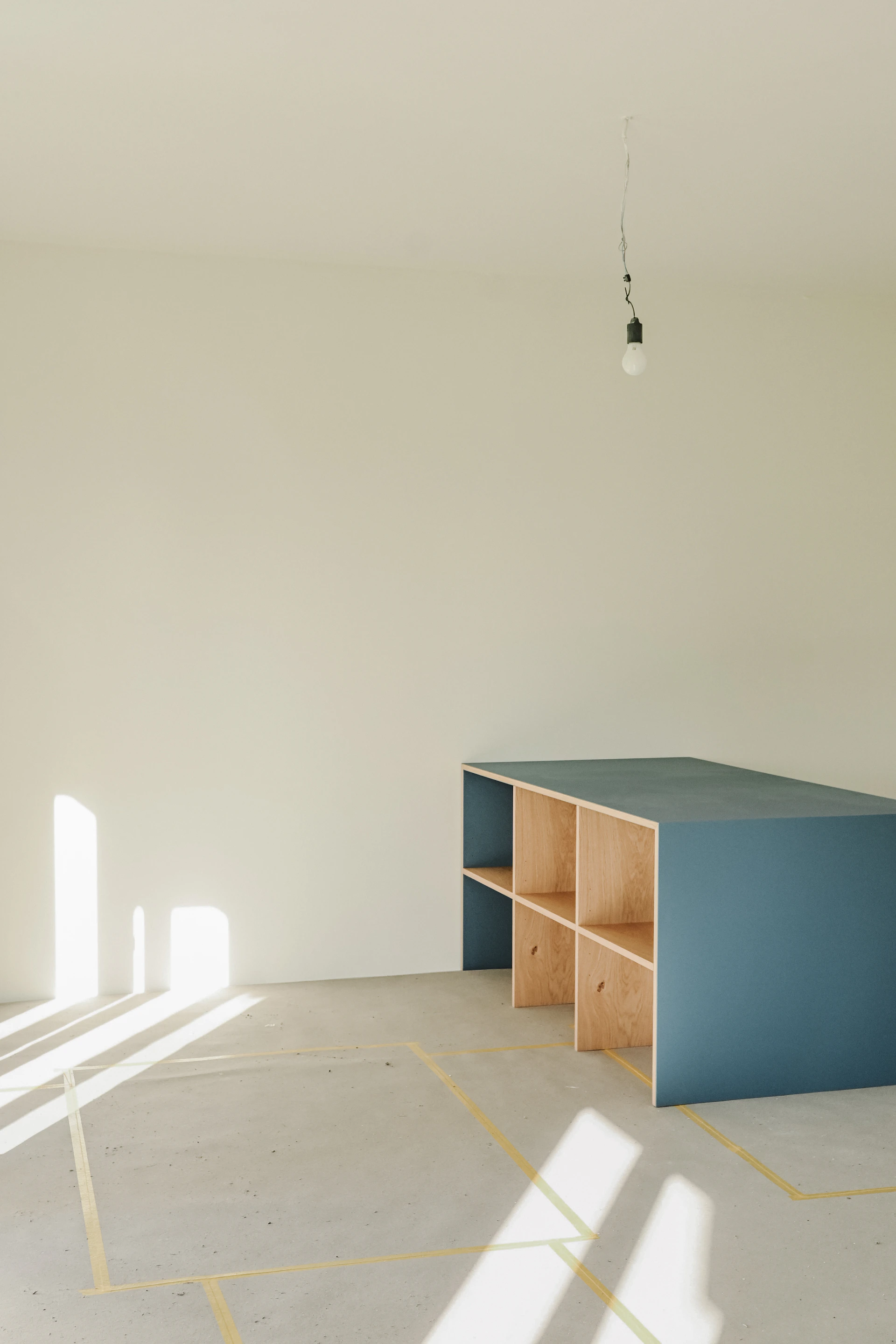 A blue shelf unit in an empty room.