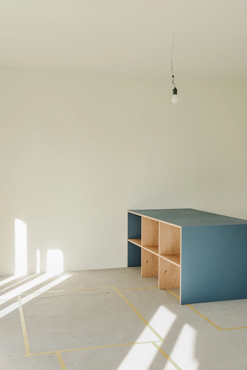 A blue shelf unit in an empty room.