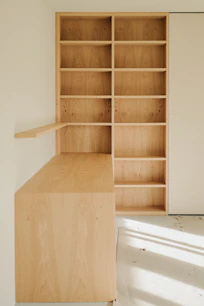 Light wood desk and bookshelf against a wall