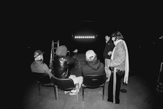 People gathered in a dark room watching a screen.