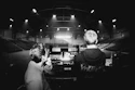 Two people watching a stage in an empty arena.