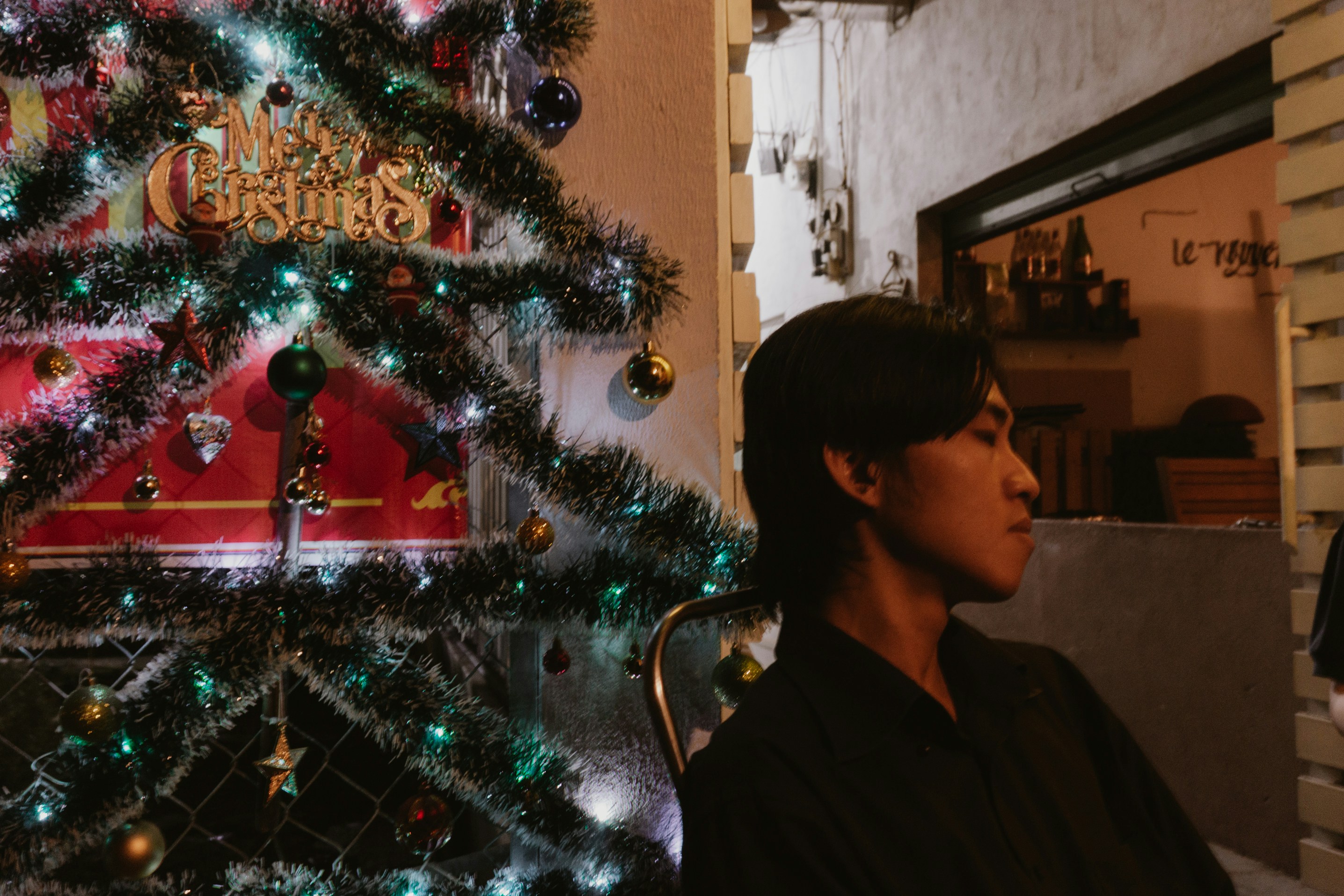 Man sitting near a decorated christmas tree