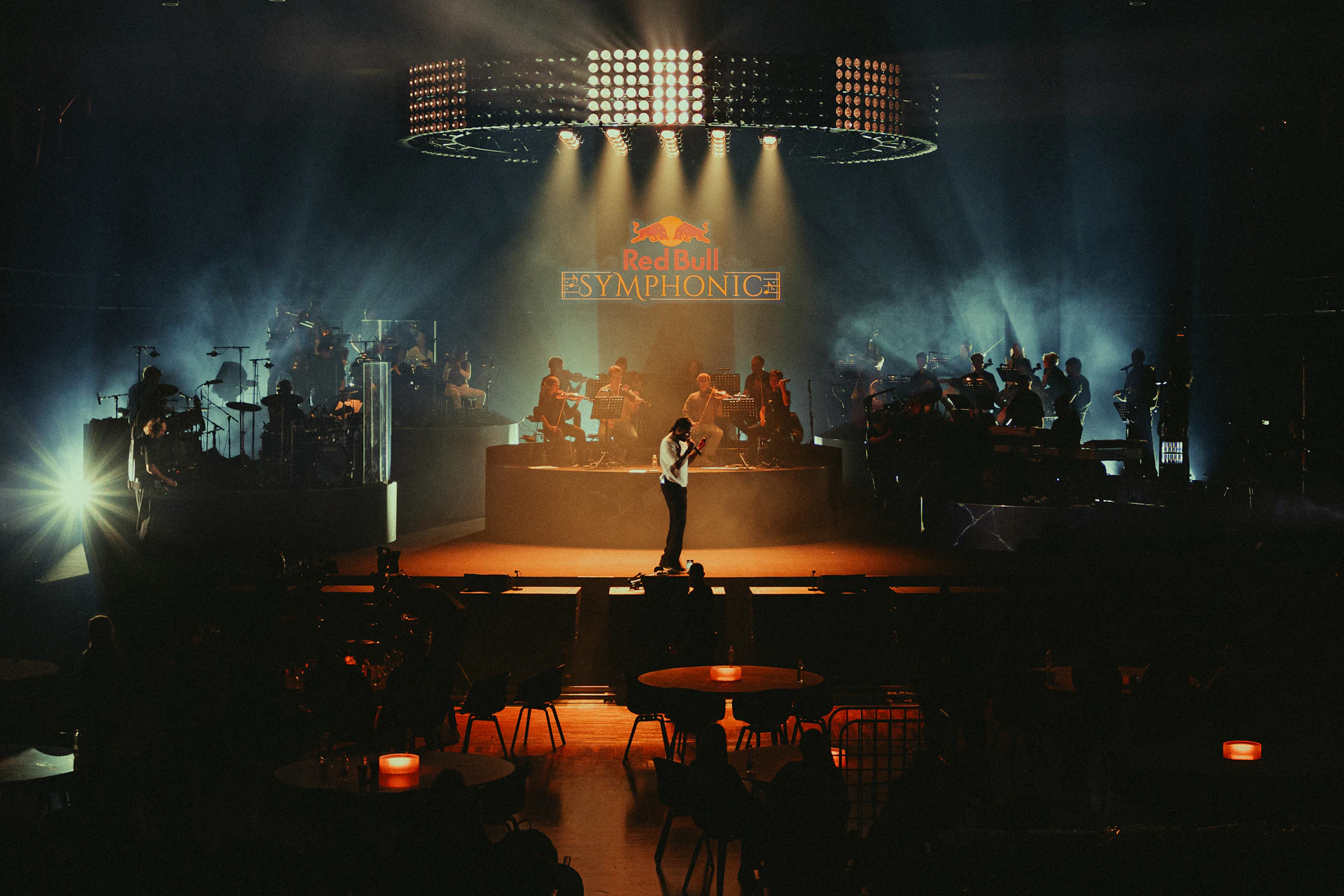 Singer performing on stage with band and lights