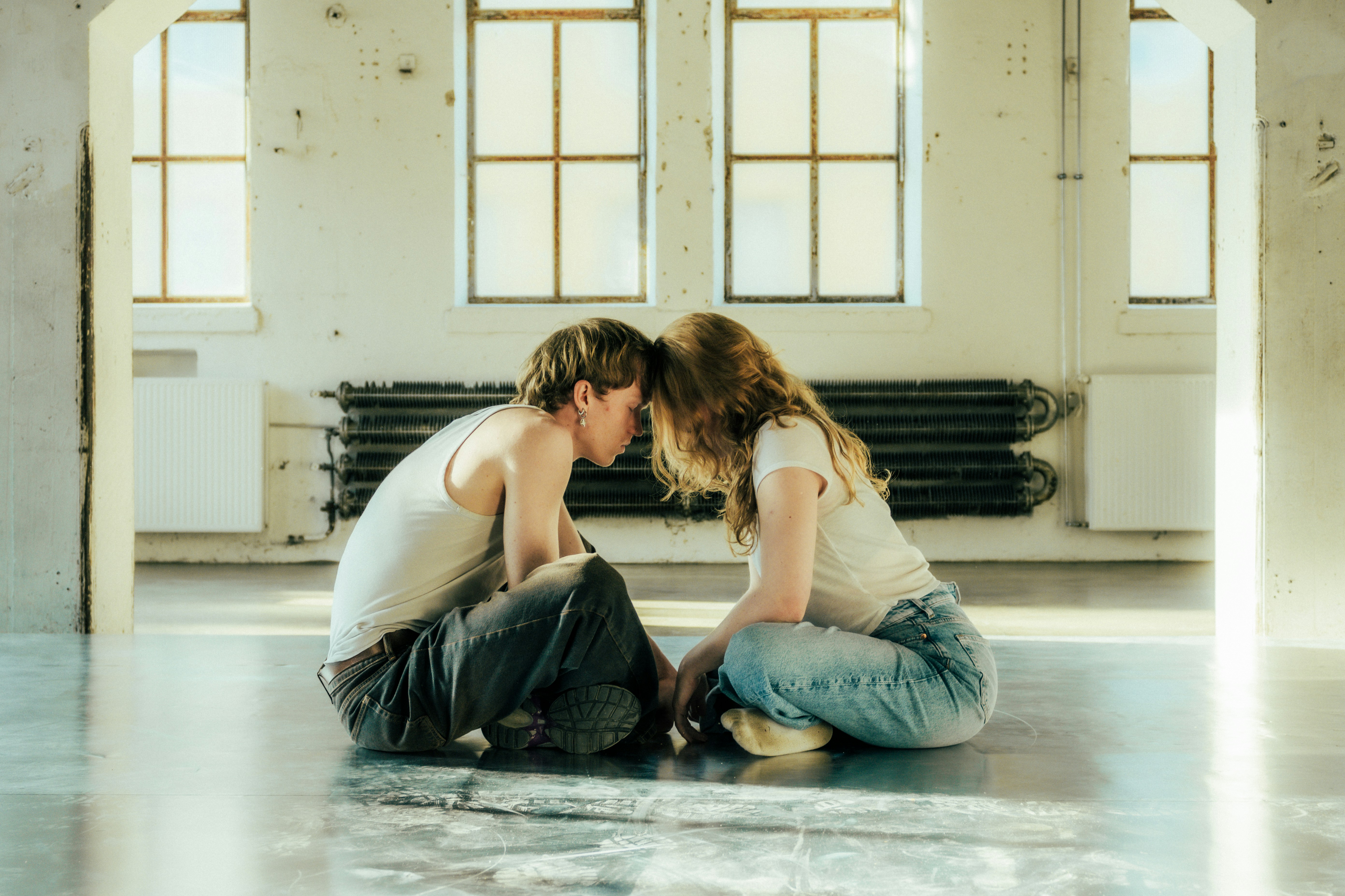 Two people touching foreheads in a bright room