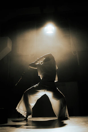 Dancer illuminated by stage light in smoky room