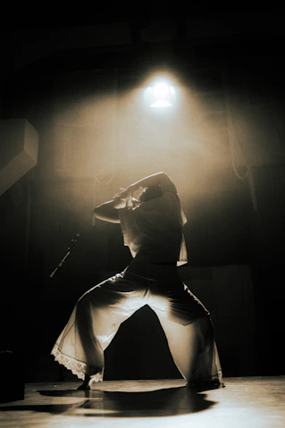 Dancer illuminated by stage light in smoky room