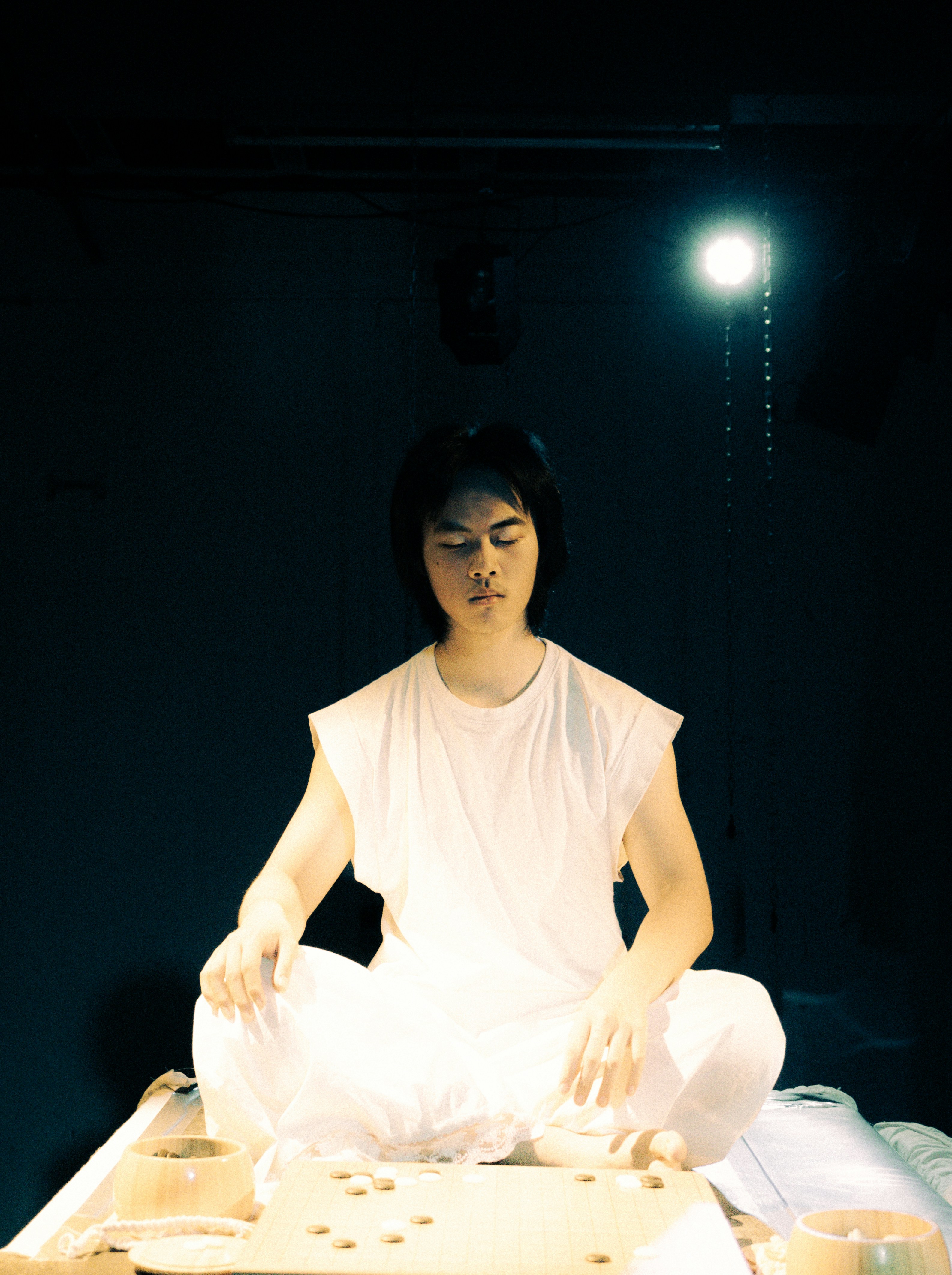 A man meditating in a white outfit