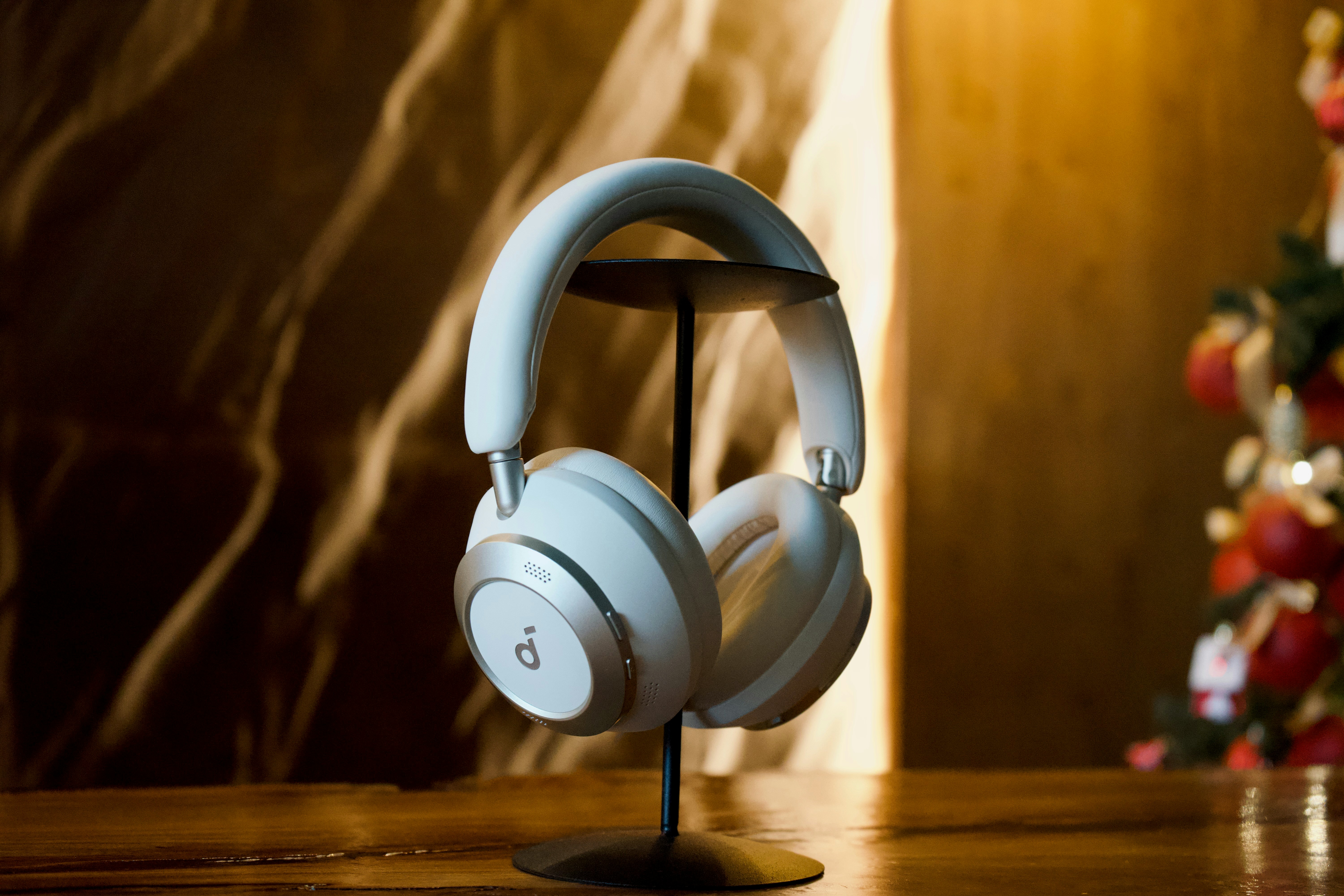 White headphones displayed on a stand with bokeh background