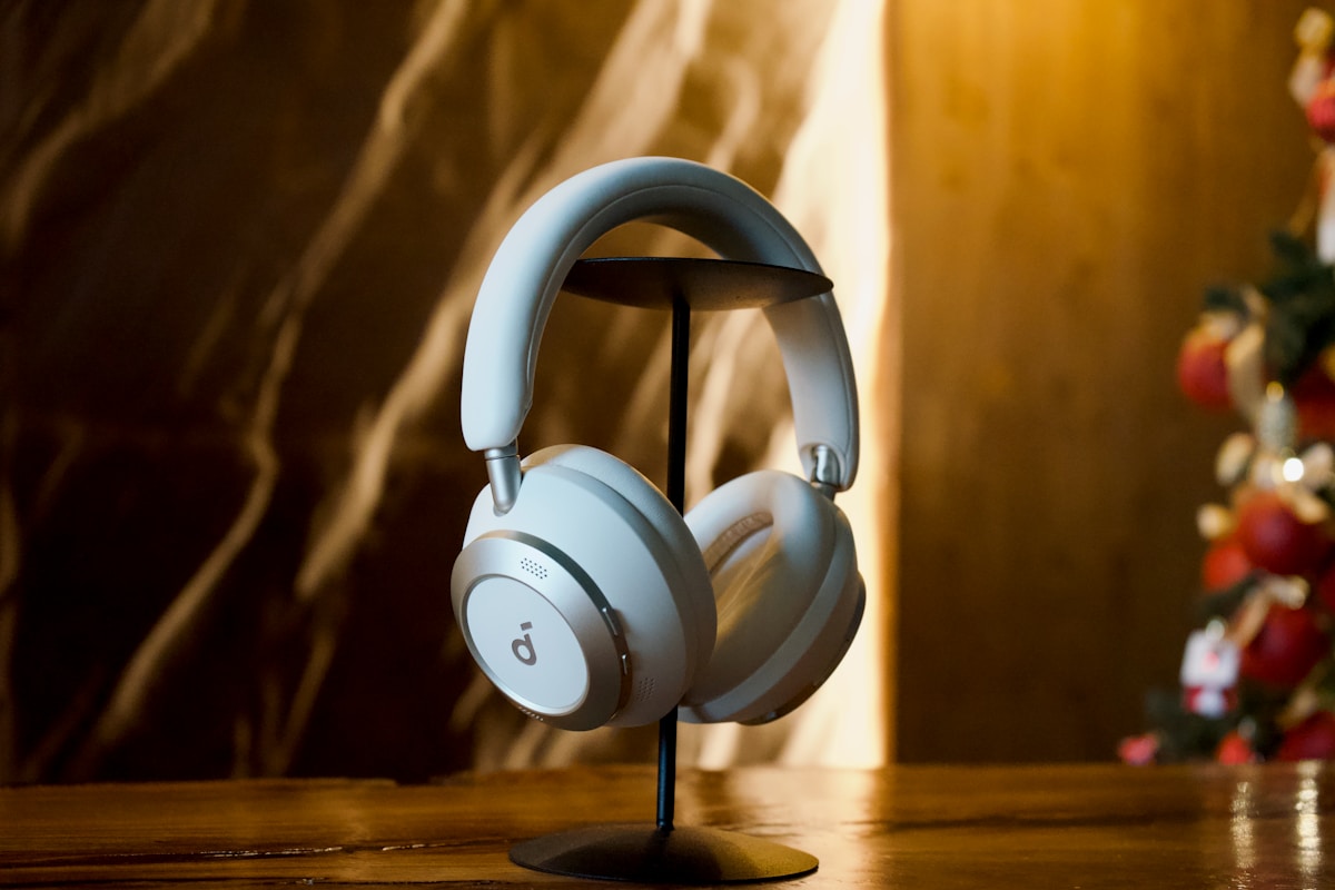 White headphones displayed on a stand with bokeh background