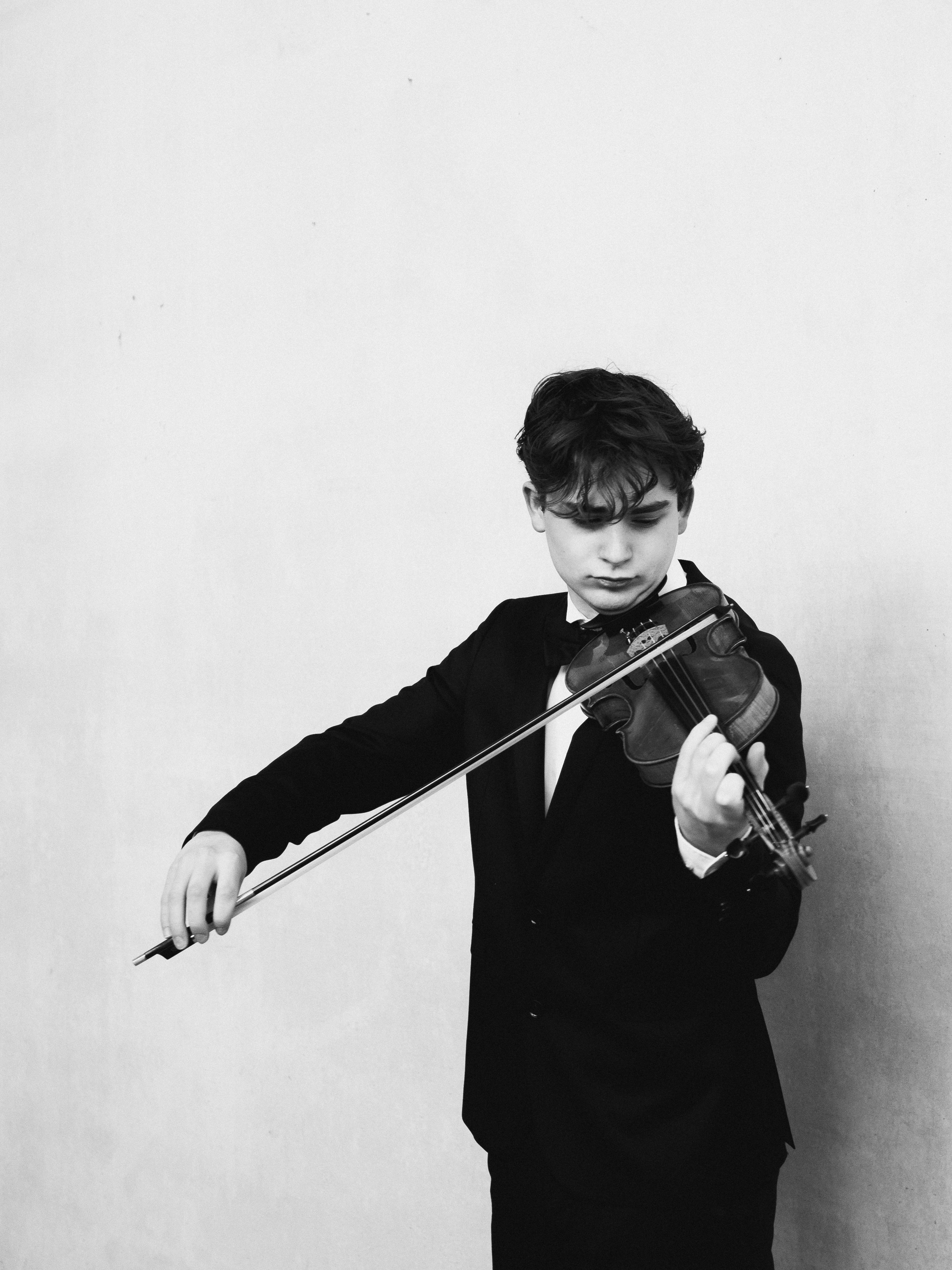 Jeune garçon en costume joue du violon