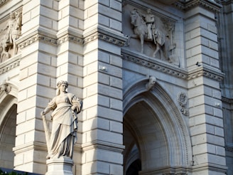 Stone statues adorn ornate building facade