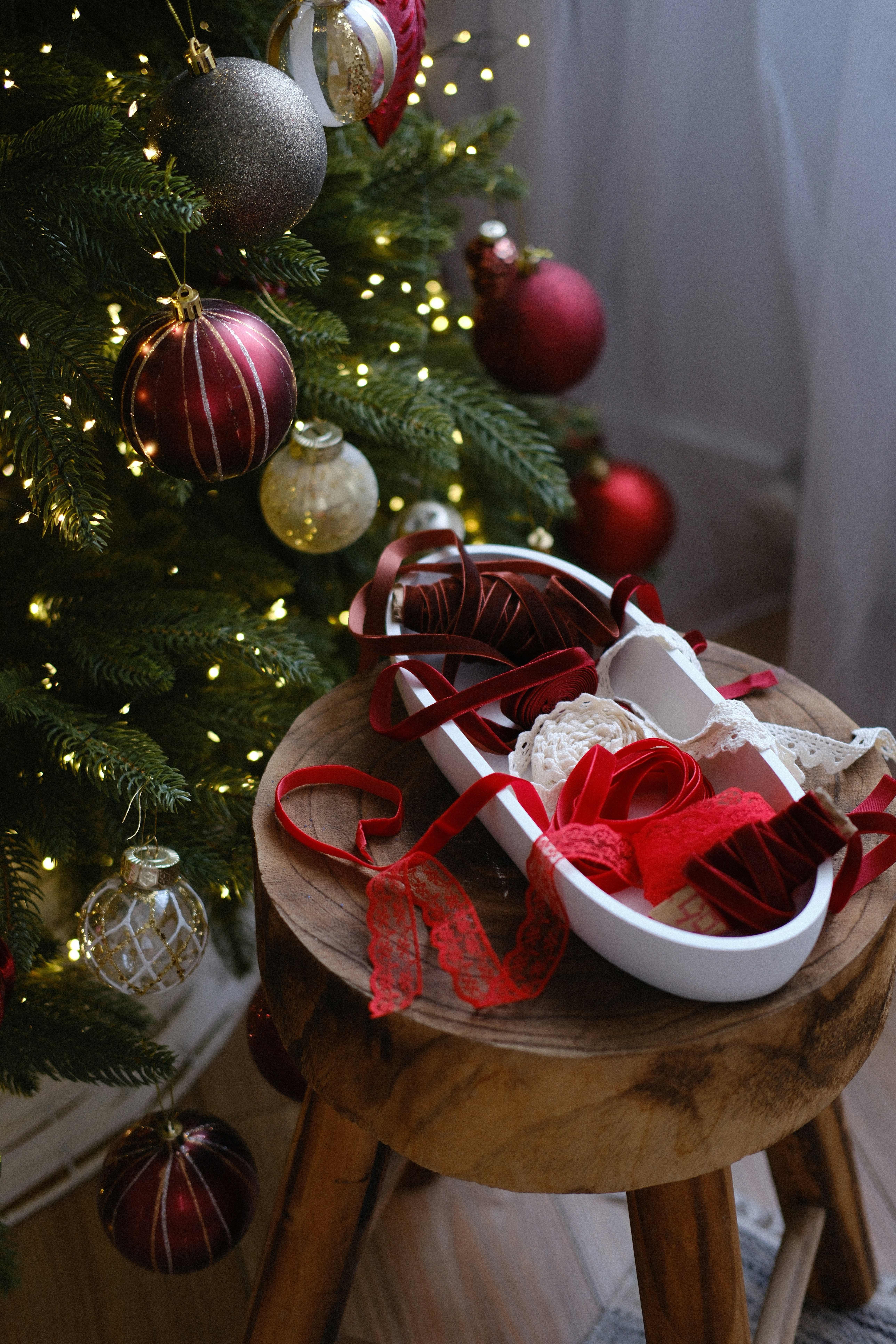 Christmas tree decorations and ribbons on a wooden stool